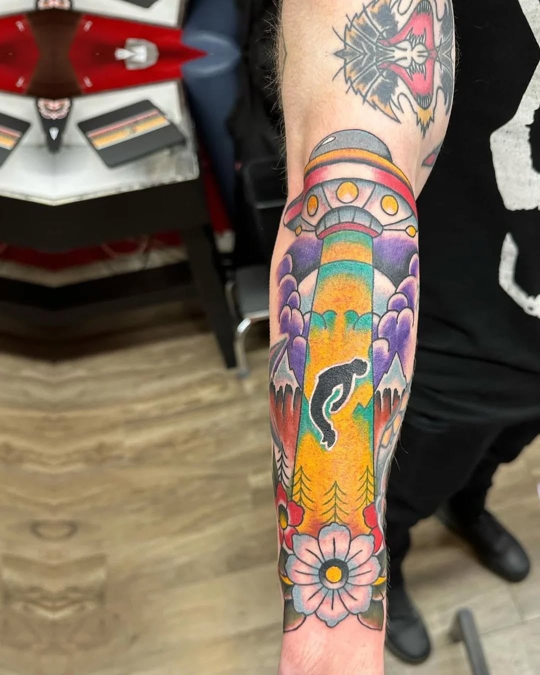 UFO abducting a person American traditional tattoo on the forearm by Murl Dietrich