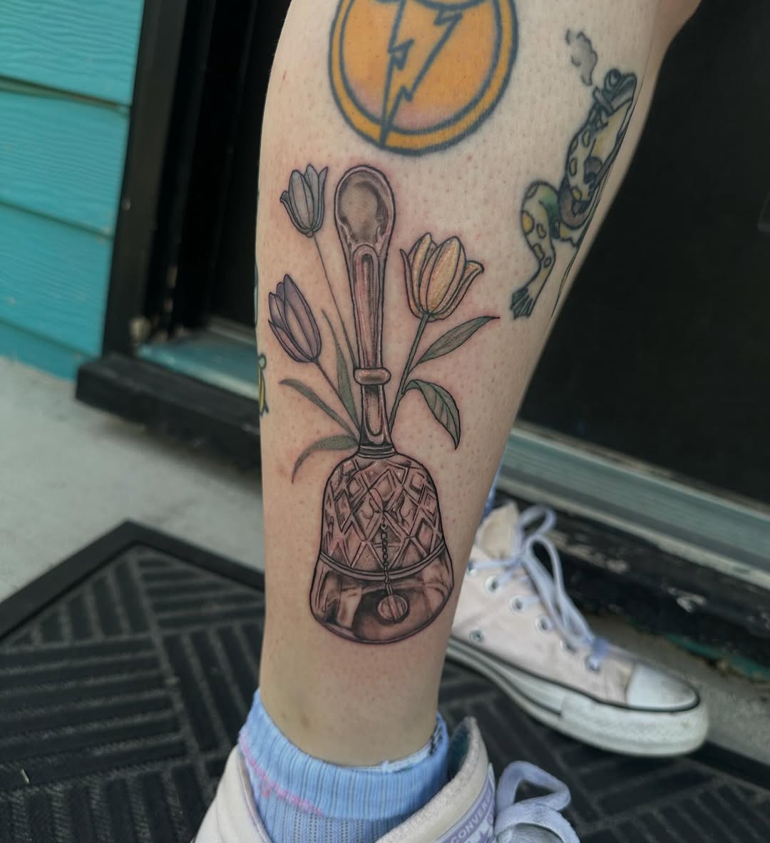 Bell with tulips tattoo on the forearm by Mika'la Berry
