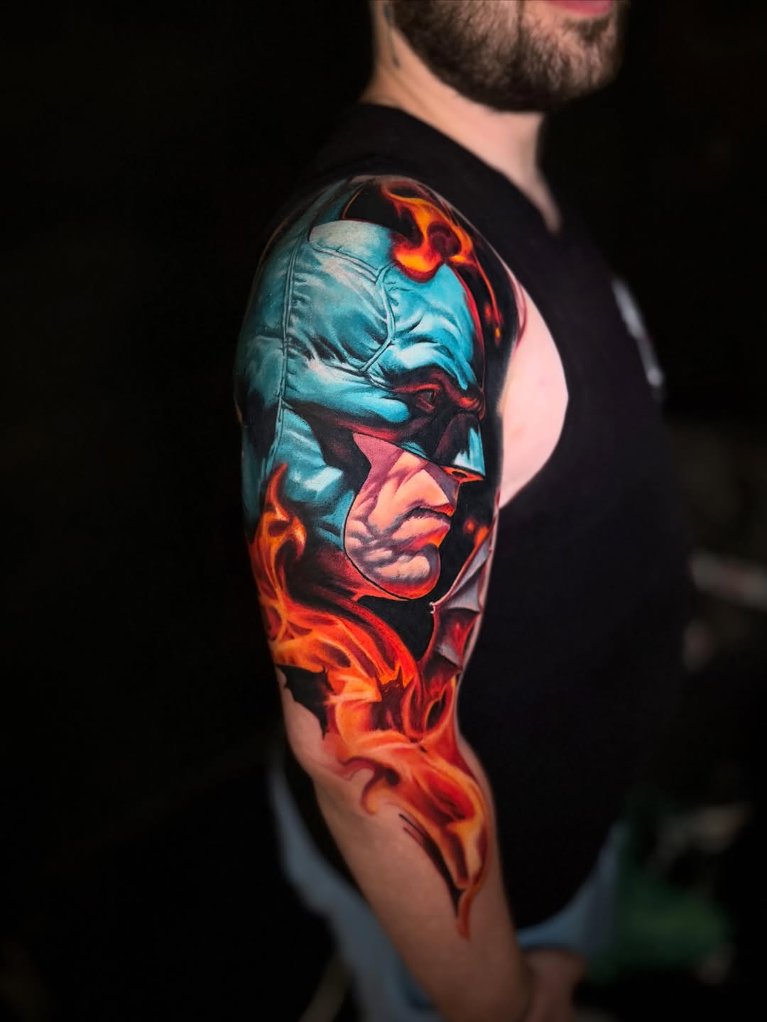 Batman in flames realism tattoo on the upper arm by Tony Ink