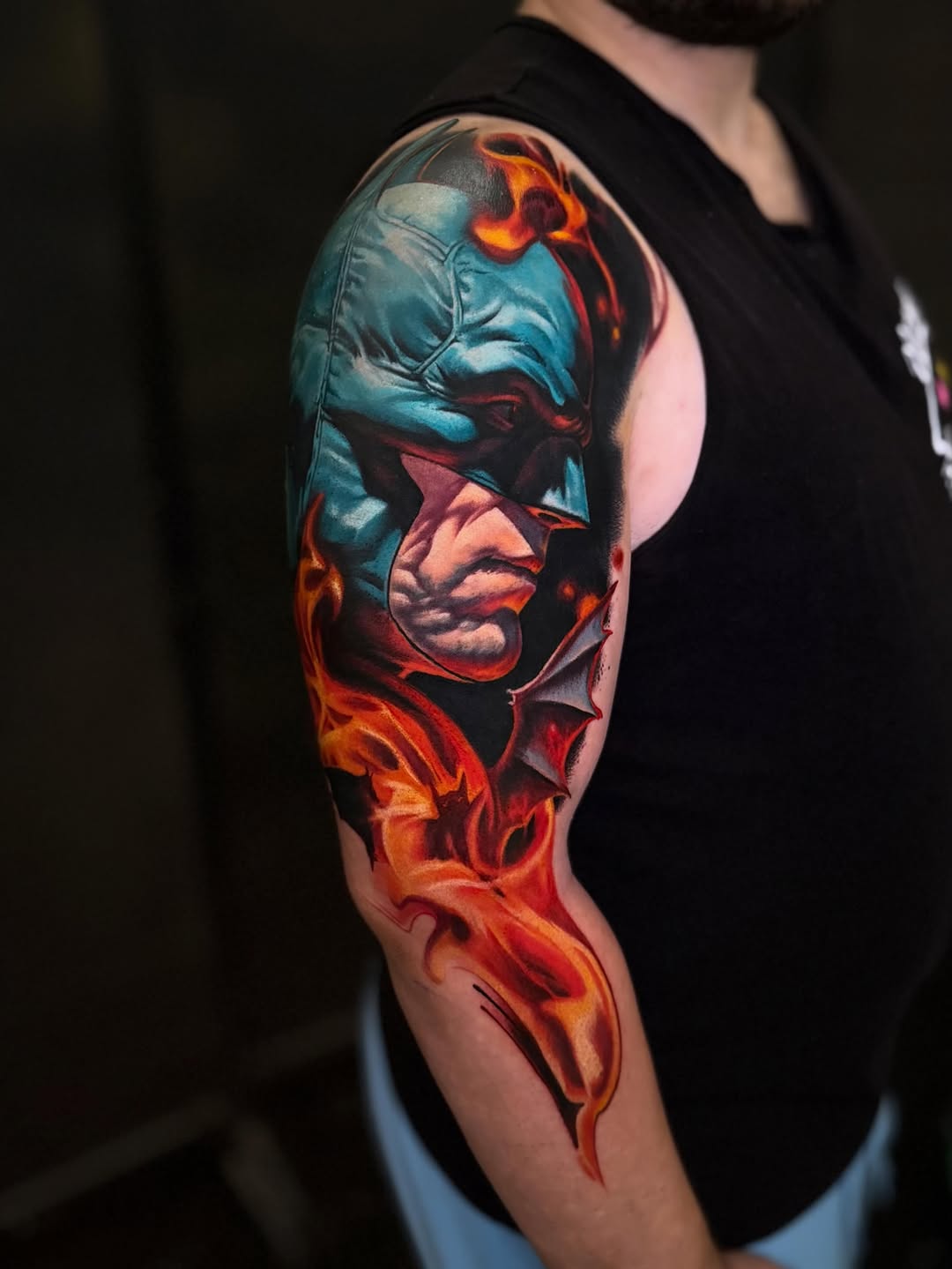 Batman in flames realism tattoo on the upper arm by Tony Ink