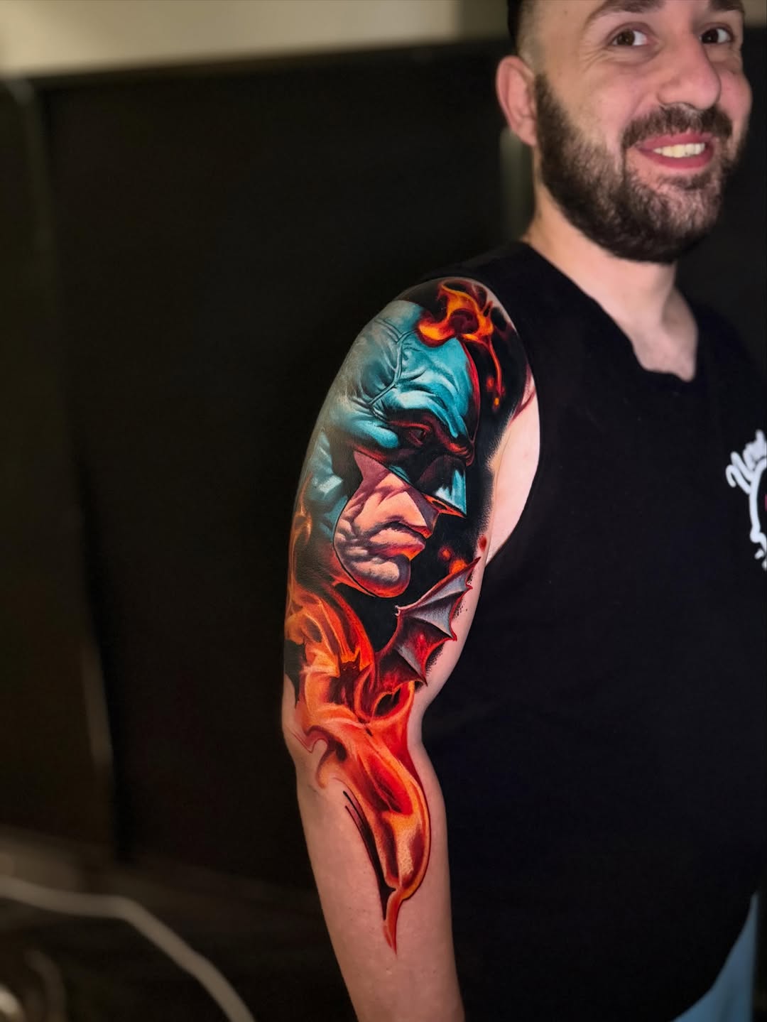 Batman with flames realism tattoo on the upper arm by Tony Ink