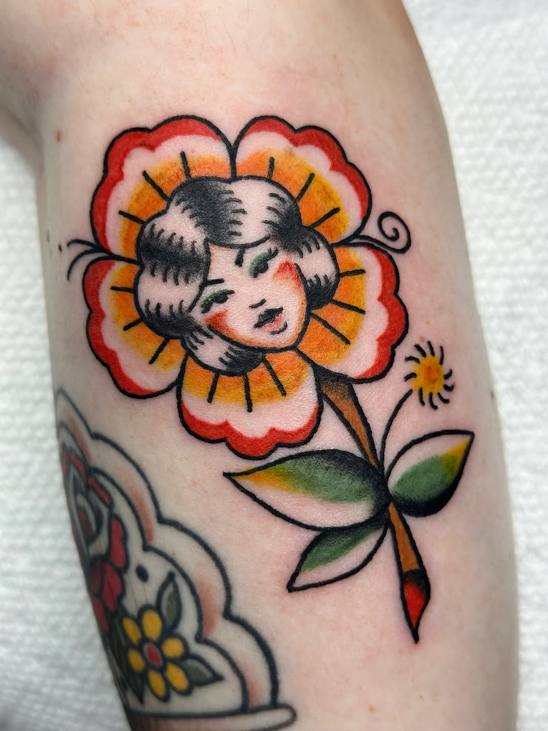 Woman face in flower neo-traditional tattoo on the forearm by Lucy Jay