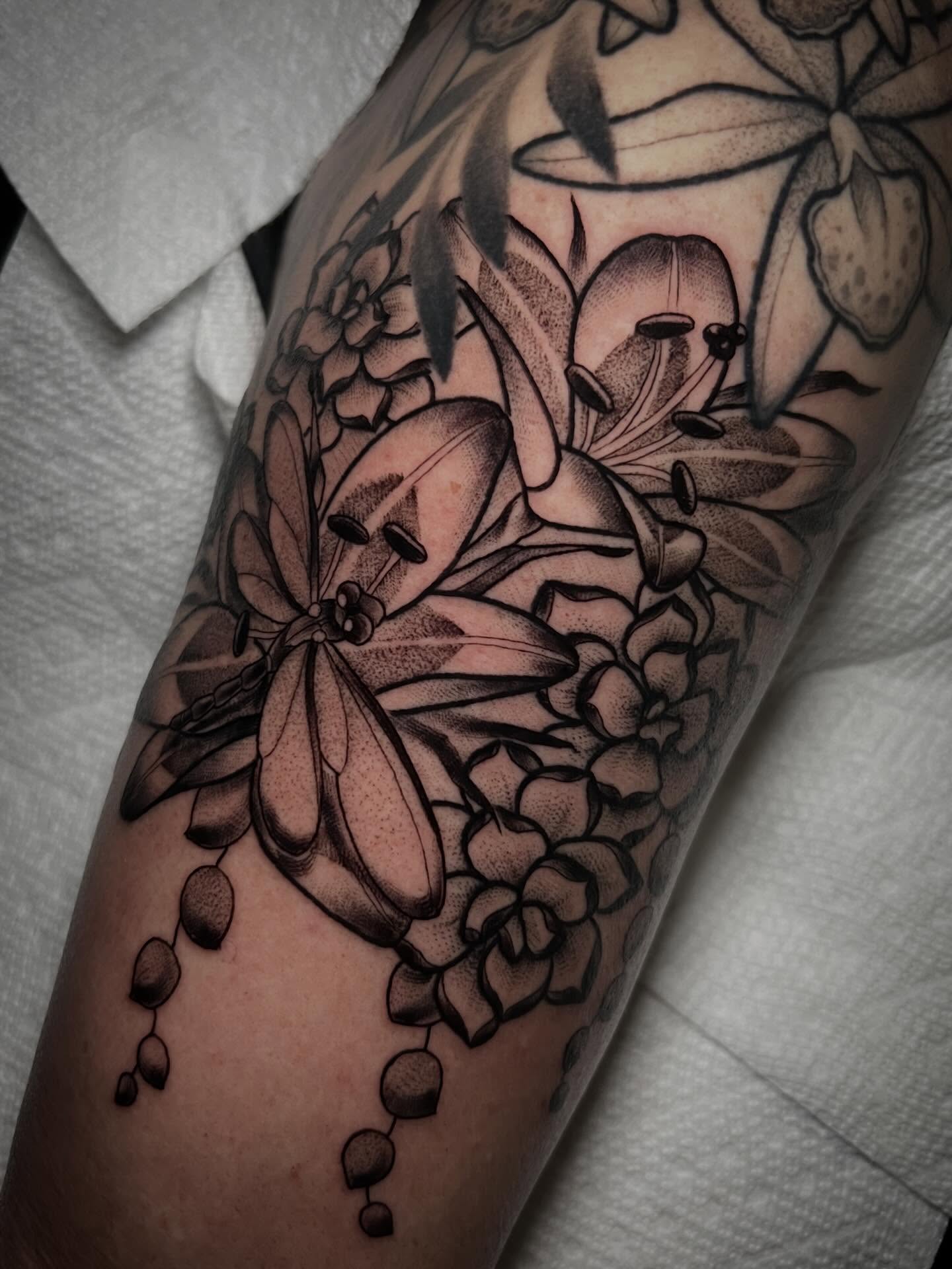 Lilies and flowers black and grey tattoo on the forearm by Katie Ann Tattoos