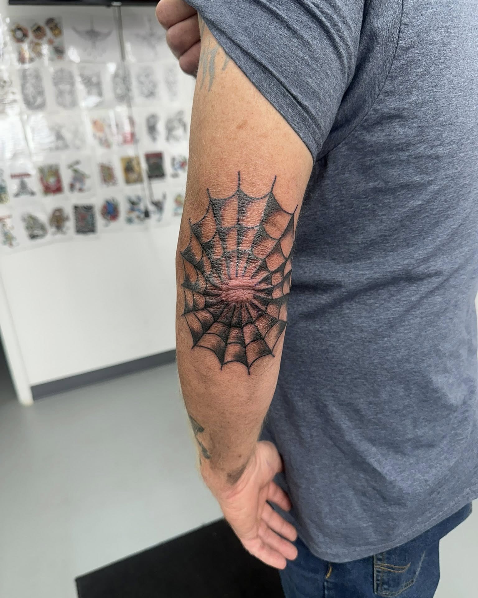 Spider web geometric tattoo on the forearm by Brian Lambert