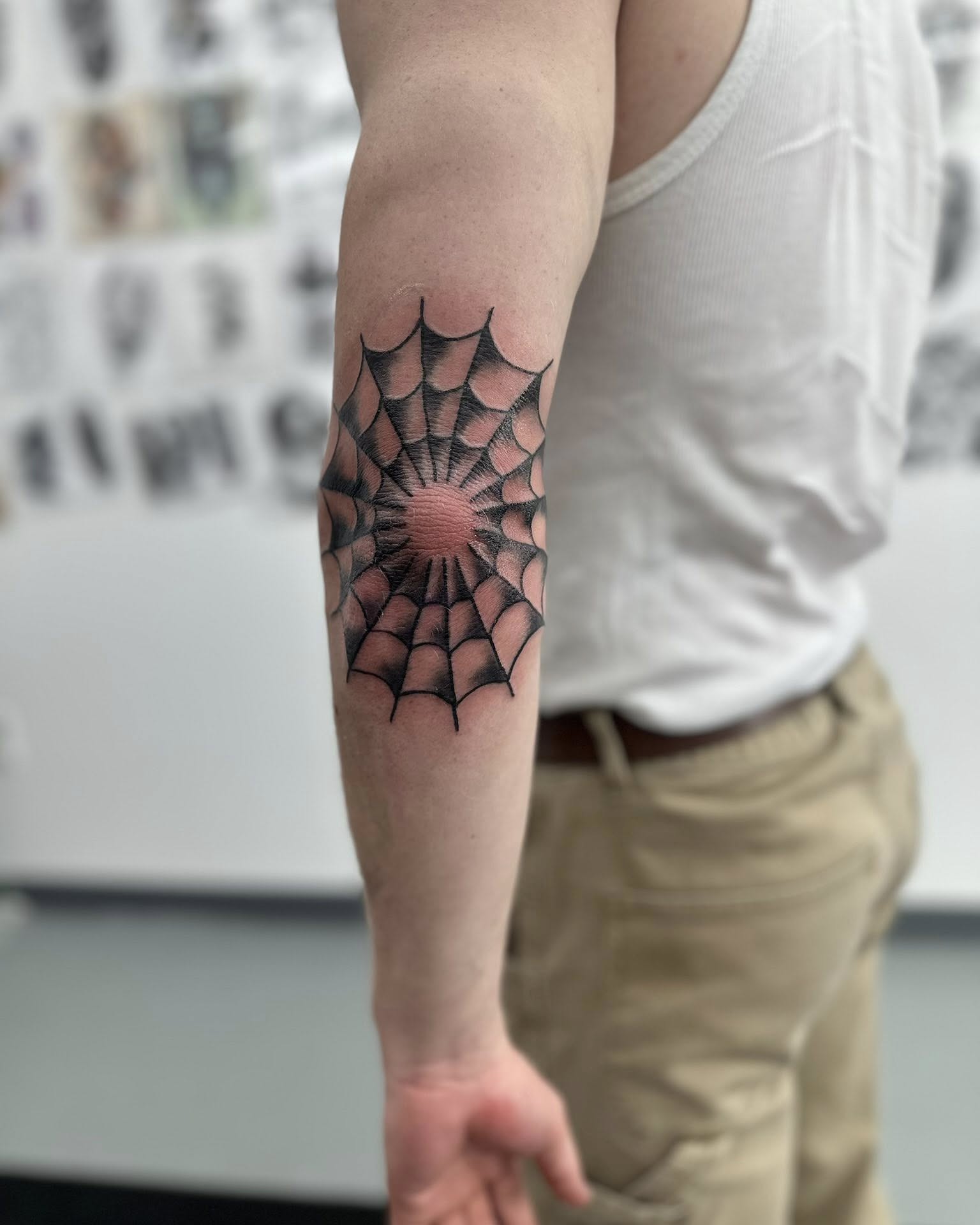 Spiderweb geometric tattoo on the forearm by Brian Lambert