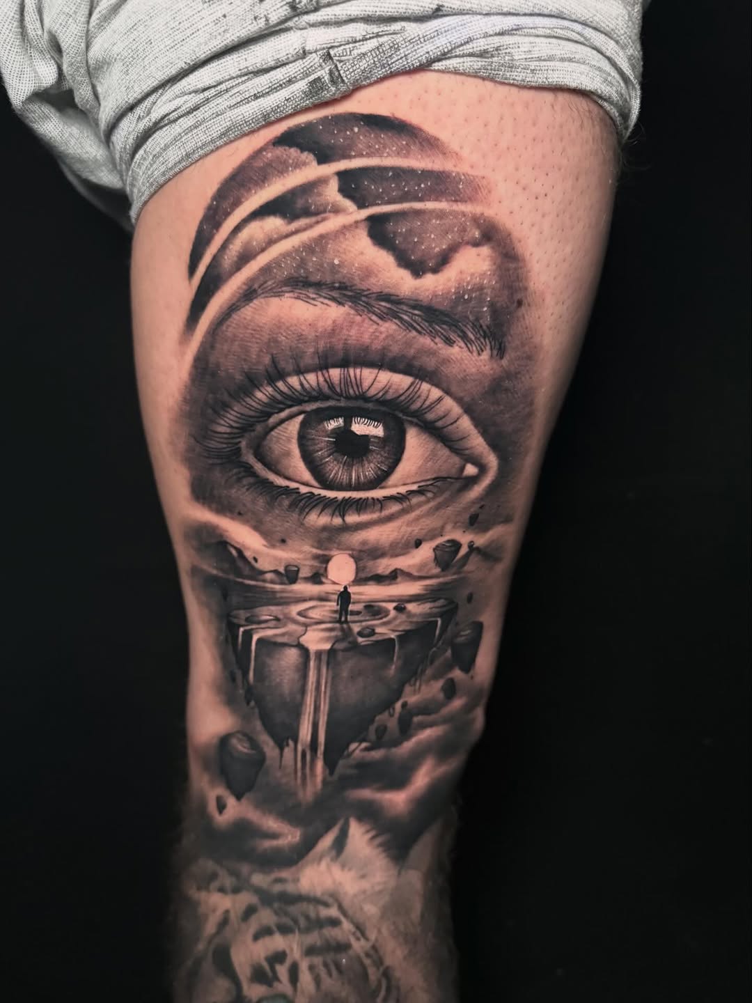 Eye with floating island and figure surrealism tattoo on the forearm by George Maldonado Austin, Austin, Texas