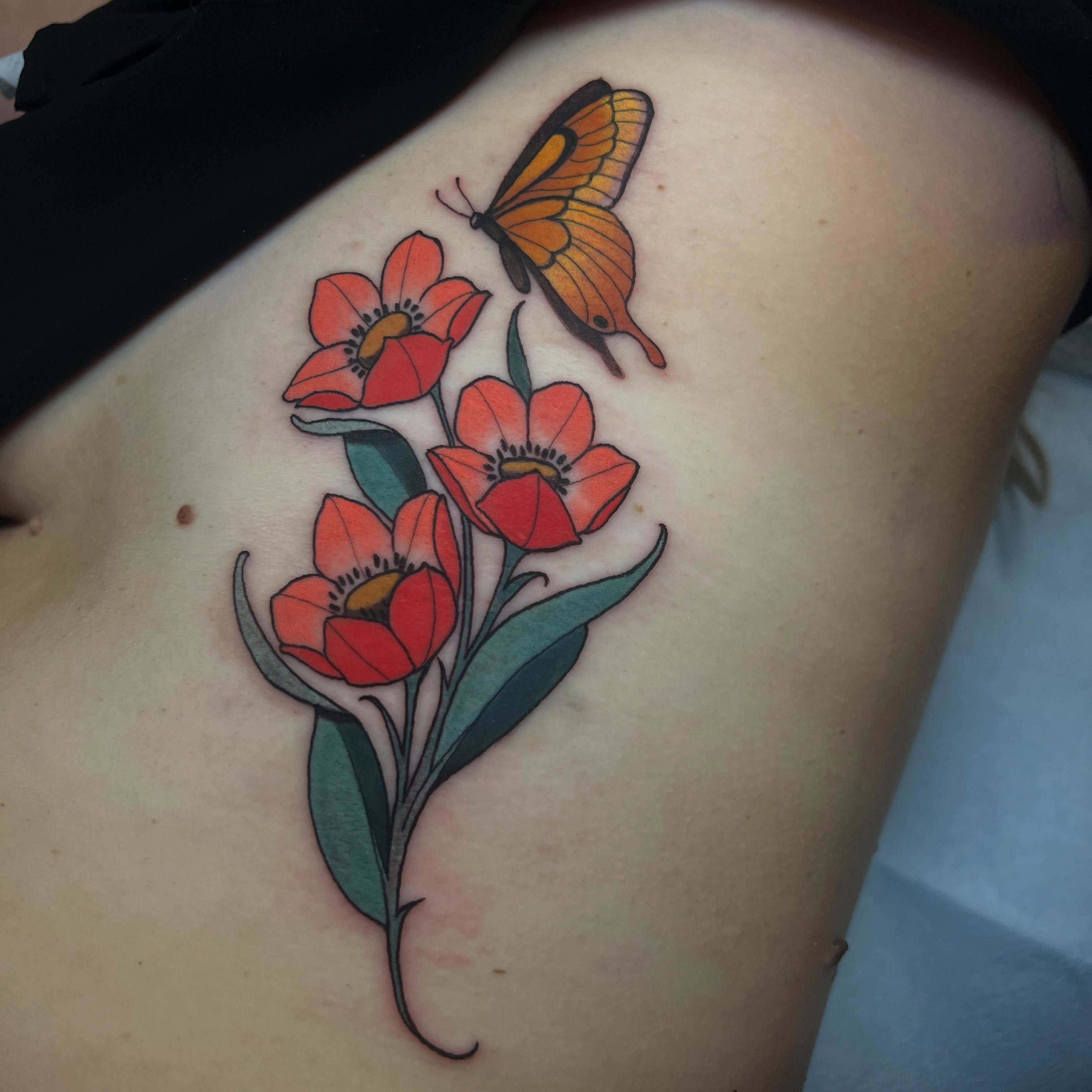 Flowers and butterfly realism tattoo on the thigh by Rennie Tattoo