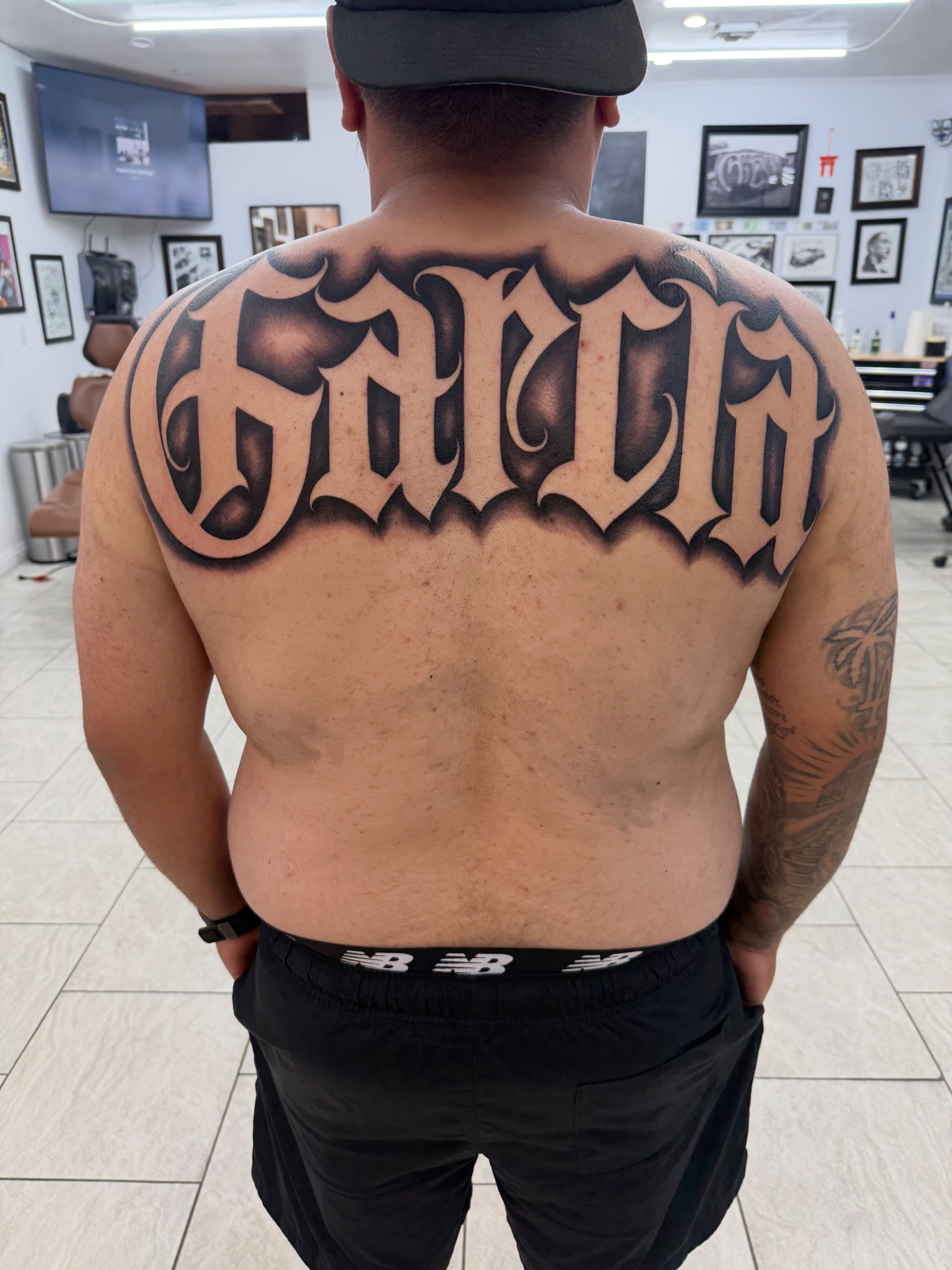 Garcia lettering script tattoo on the back by Daniel Lopez Tattoos