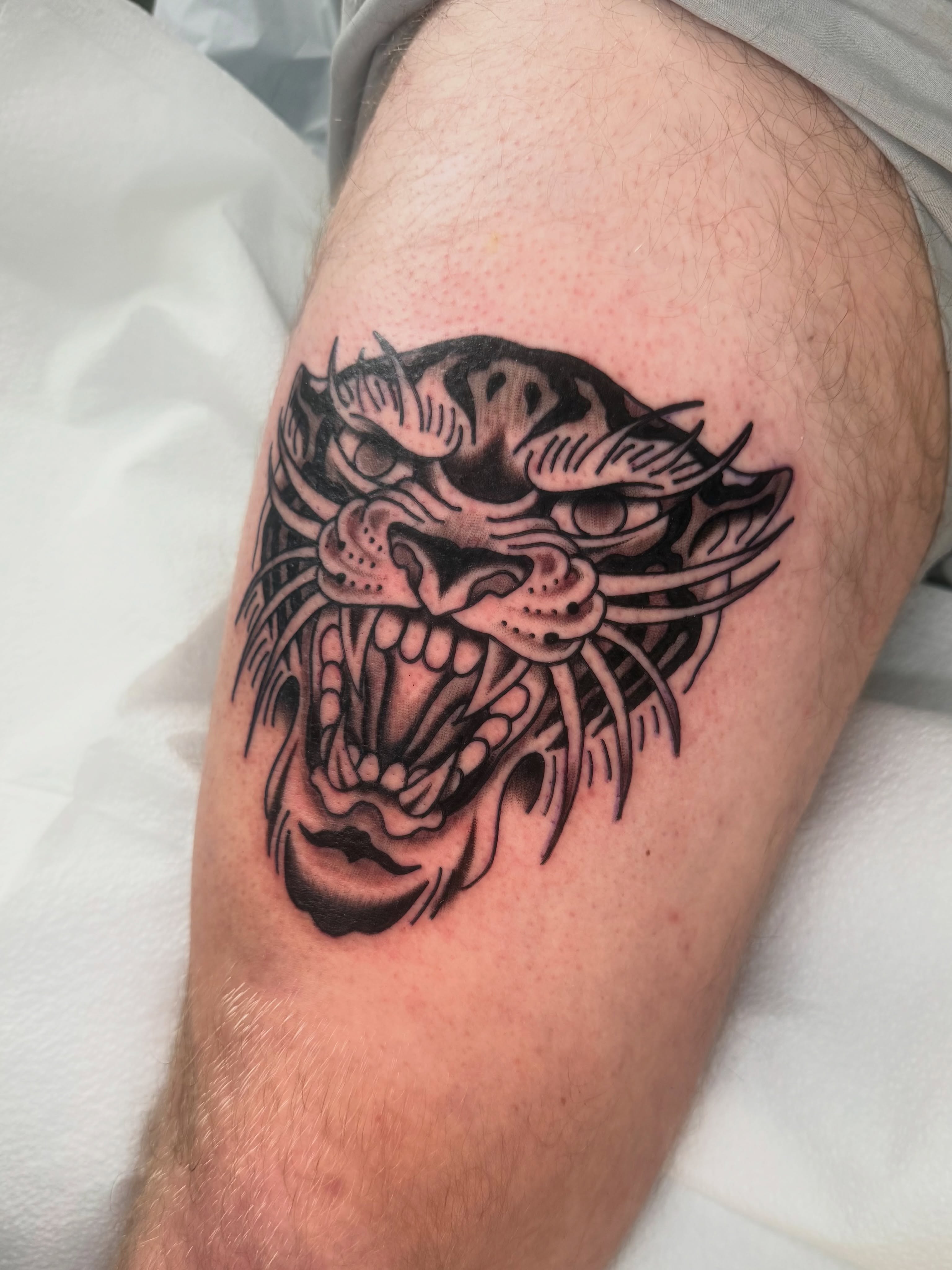 Panther black and grey tattoo on the thigh by Lexie Graff