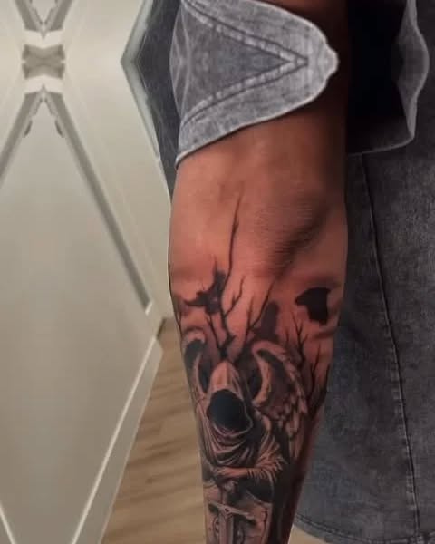 Grim reaper with wings and trees realism tattoo on the forearm by Janice Heathcote