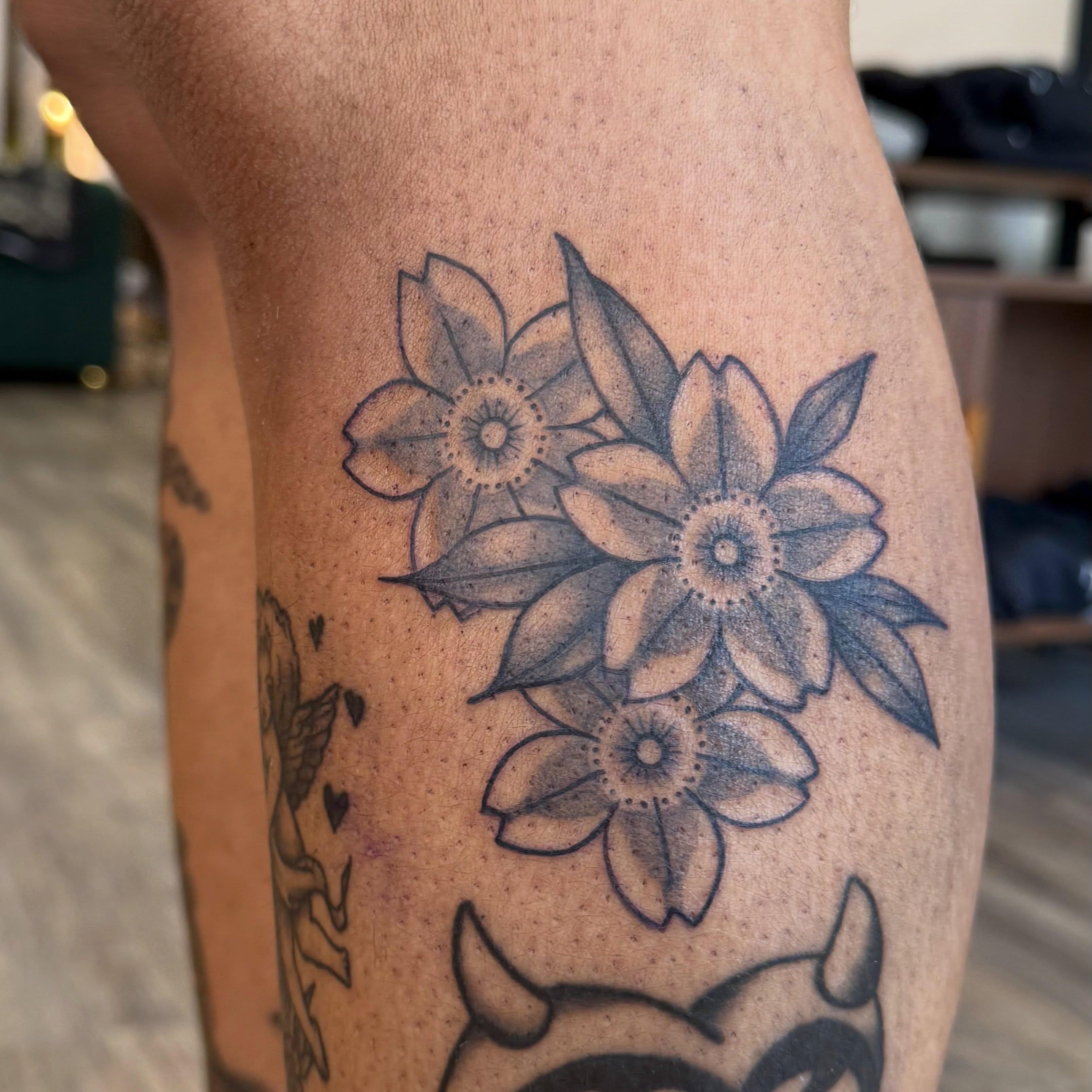 Floral bouquet black and grey tattoo on the forearm by Kate Marie