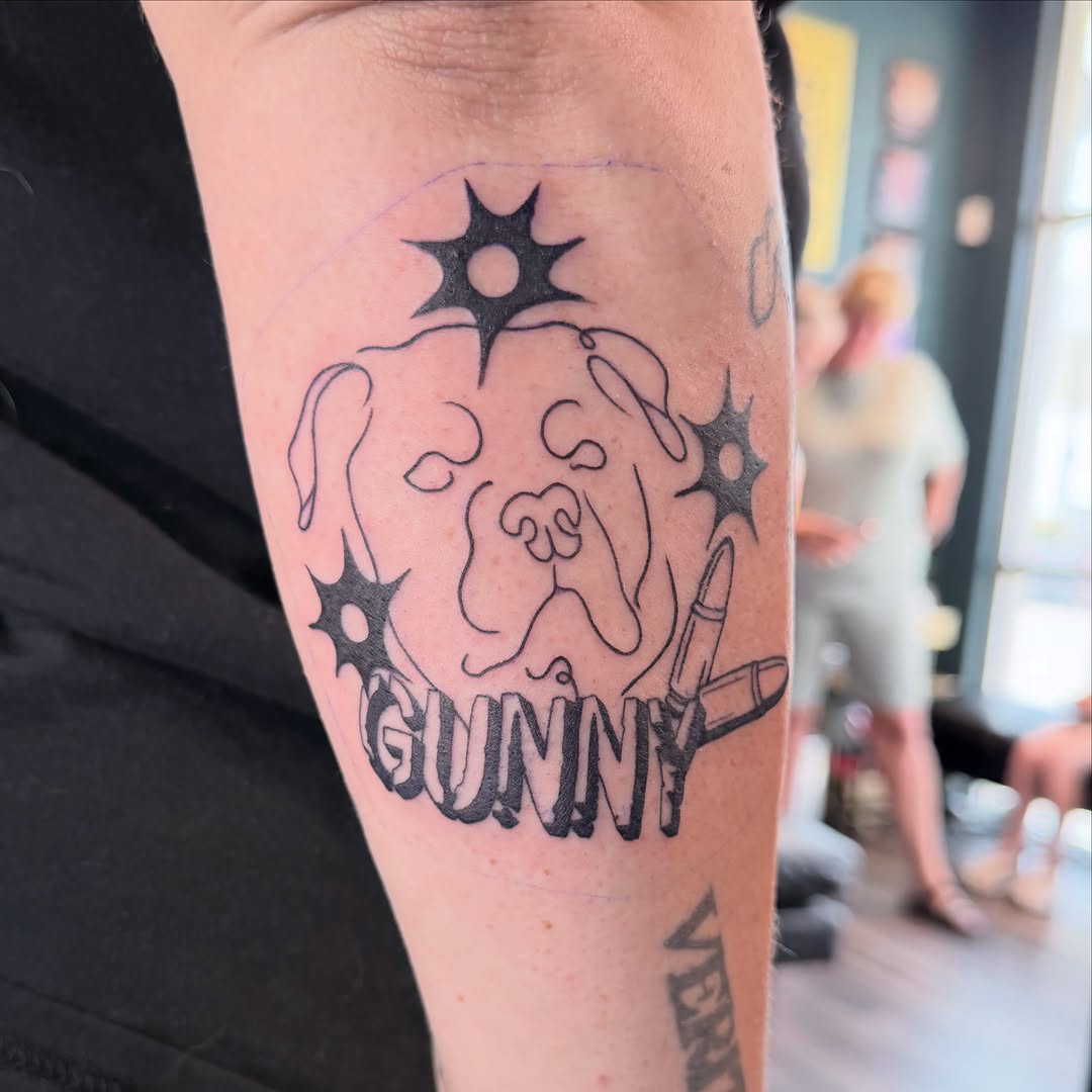 Dog portrait with bullet realism tattoo on the forearm by Sarah Lauren France