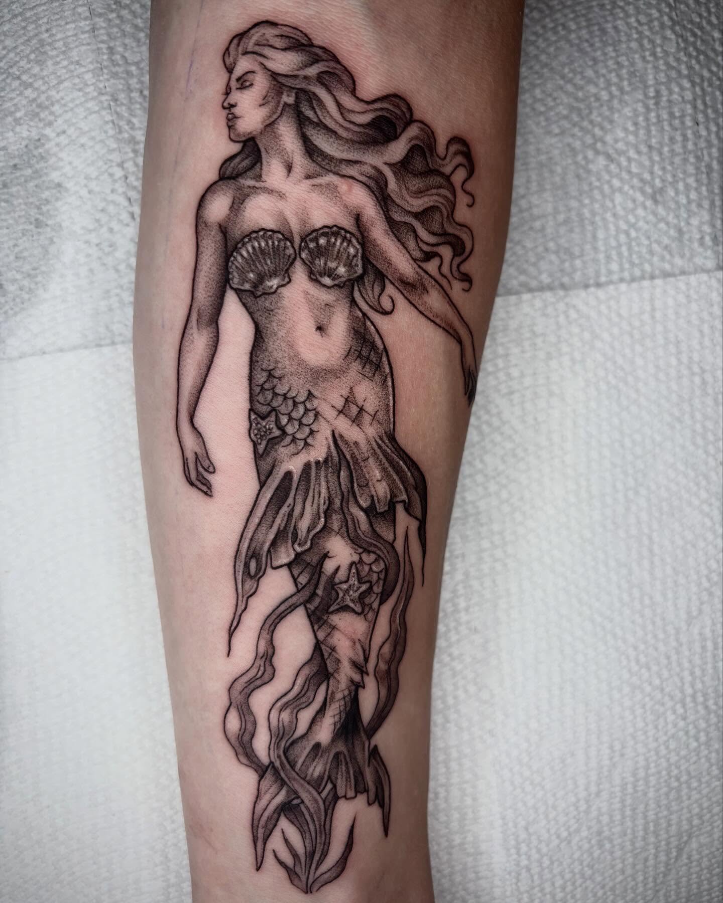 Mermaid black and grey tattoo on the forearm by Emily Falkowski