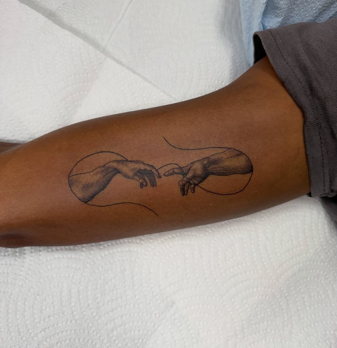 The Creation of Adam hands sketch tattoo on the forearm by Fineline tattoos by Kinsey