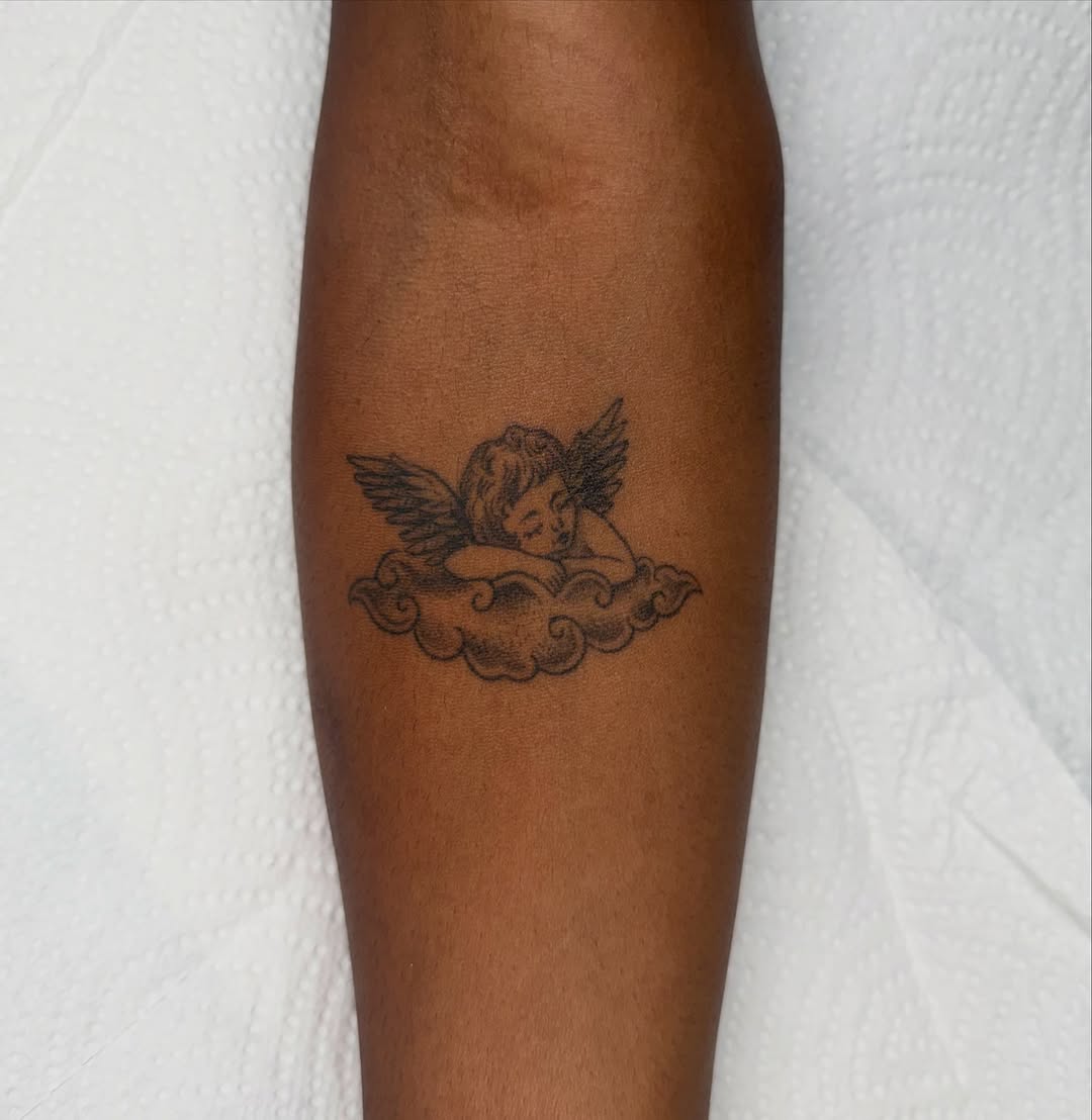 Cherub on a cloud realism tattoo on the forearm by Fineline tattoos by Kinsey