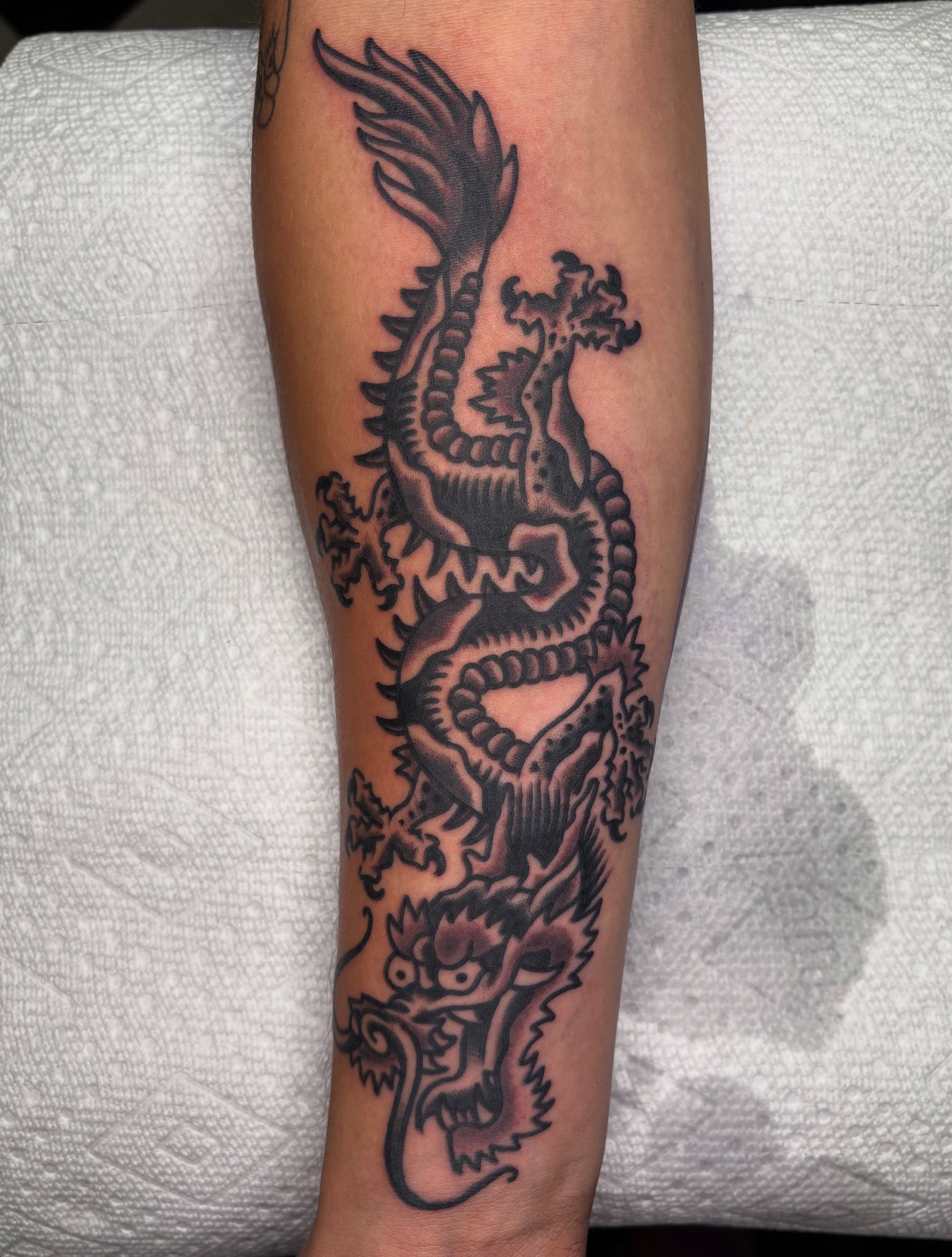 Dragon black and grey tattoo on the forearm by Andrew Silva