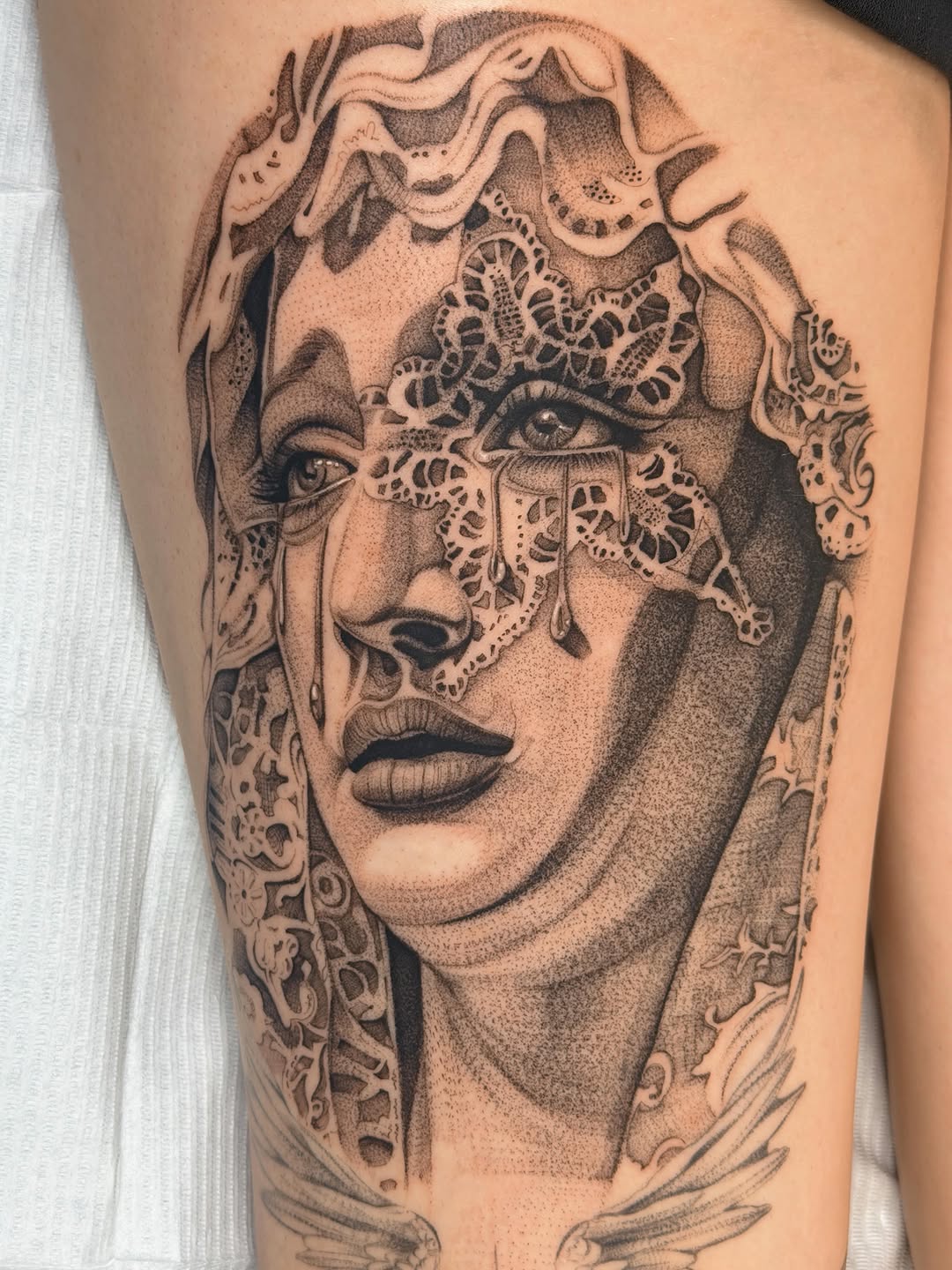 Woman with lace veil and tears realism tattoo on the thigh by Nate Weaver