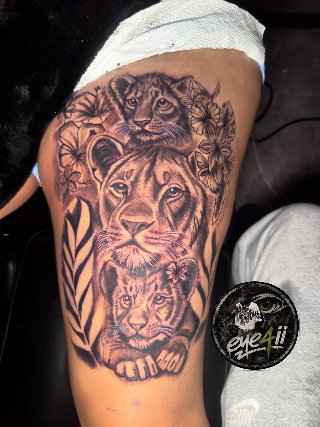 Lion family with flowers tattoo on the thigh by dallas tattoo artist, Duncanville, Texas