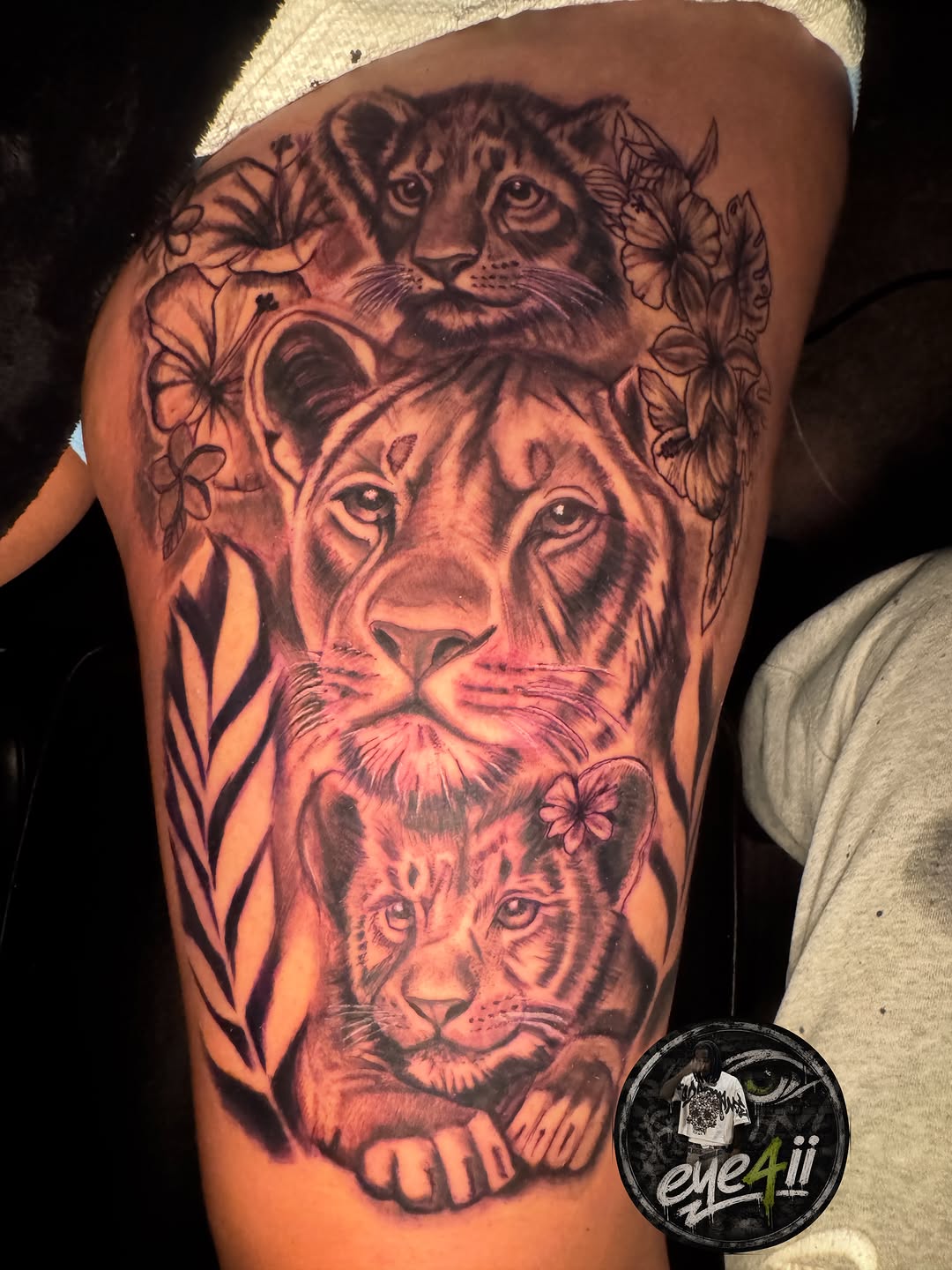 Lioness and cubs with flowers tattoo on the thigh by dallas tattoo artist, Duncanville, Texas