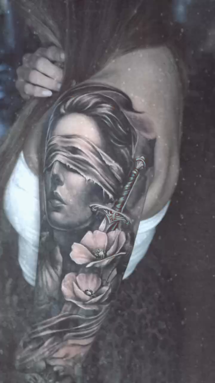Blindfolded woman with sword and flowers realism tattoo by Gregorio Devera