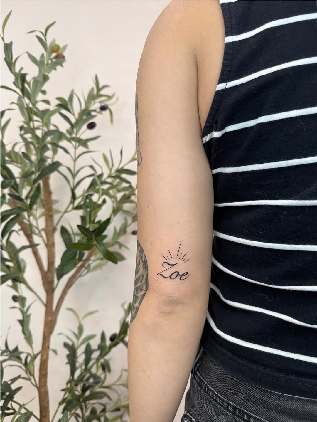 Name Zoe with crown lettering tattoo on the forearm by Joey tattoo