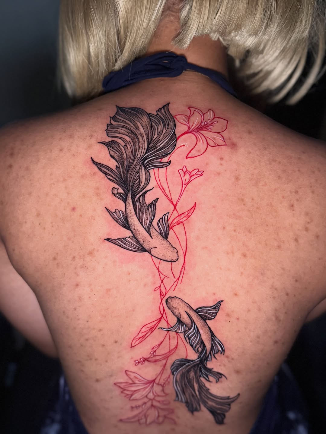 Two koi fish with red flowers fine line tattoo on the back by Aldocasales@tatto