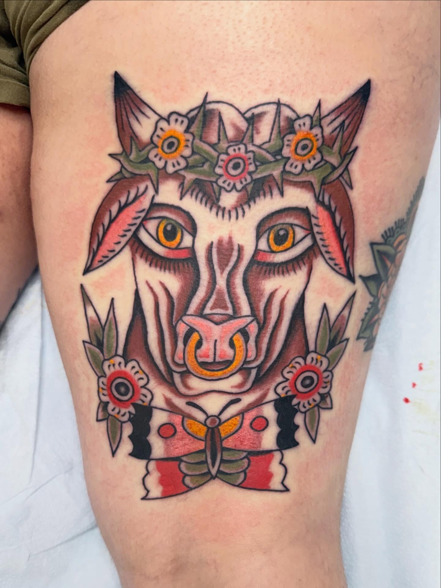 Cat with floral crown American traditional tattoo on the thigh by Jacqui Rose