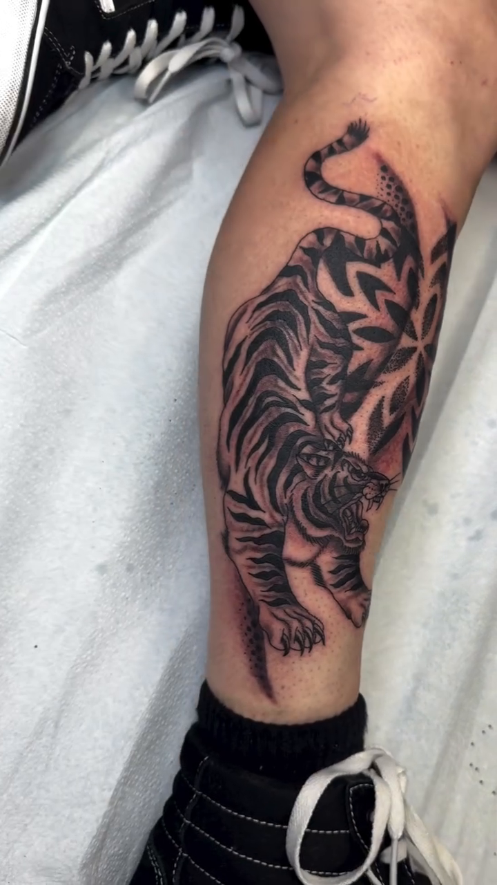 Tiger with floral elements realism tattoo on the forearm by Michael Roehrich (MEECH!)