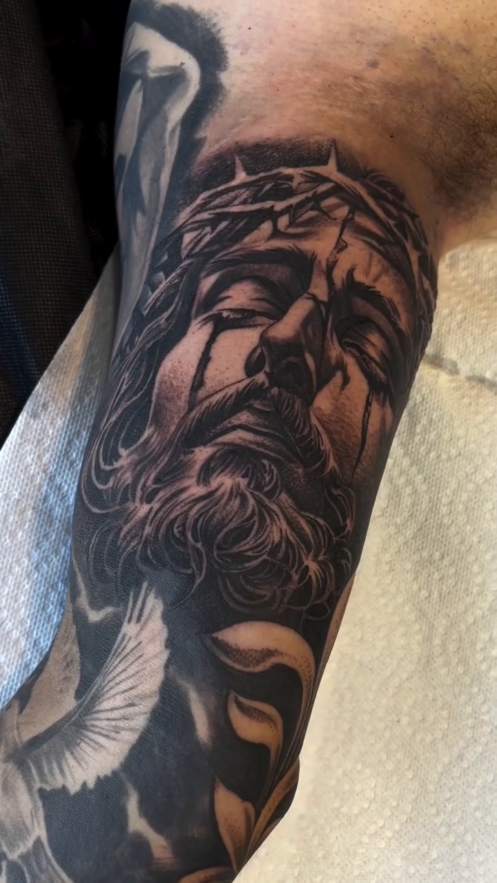 Jesus Christ portrait with doves realism tattoo on the forearm by michael