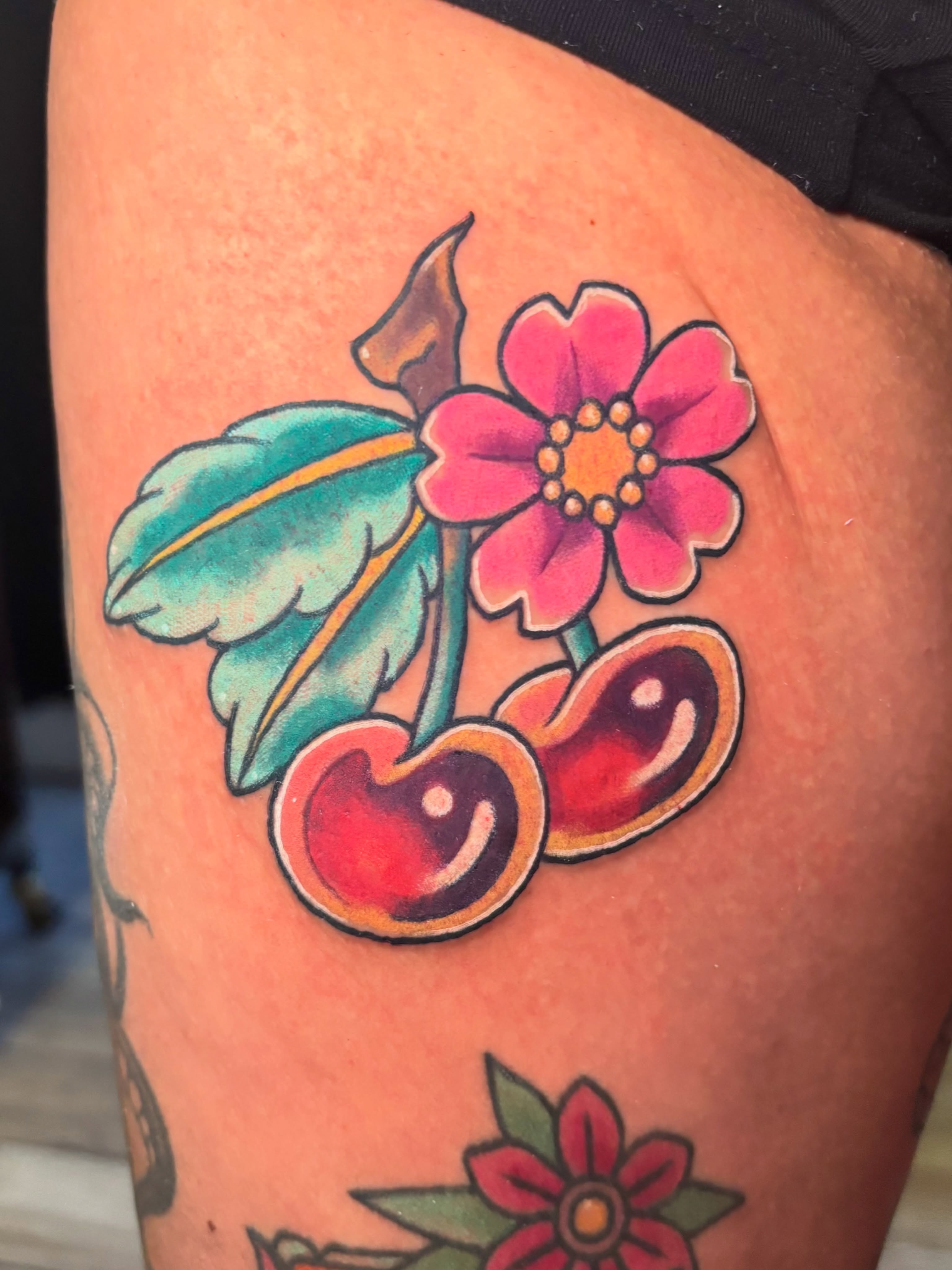 Cherry blossom American traditional tattoo on the thigh by Bekah Smith