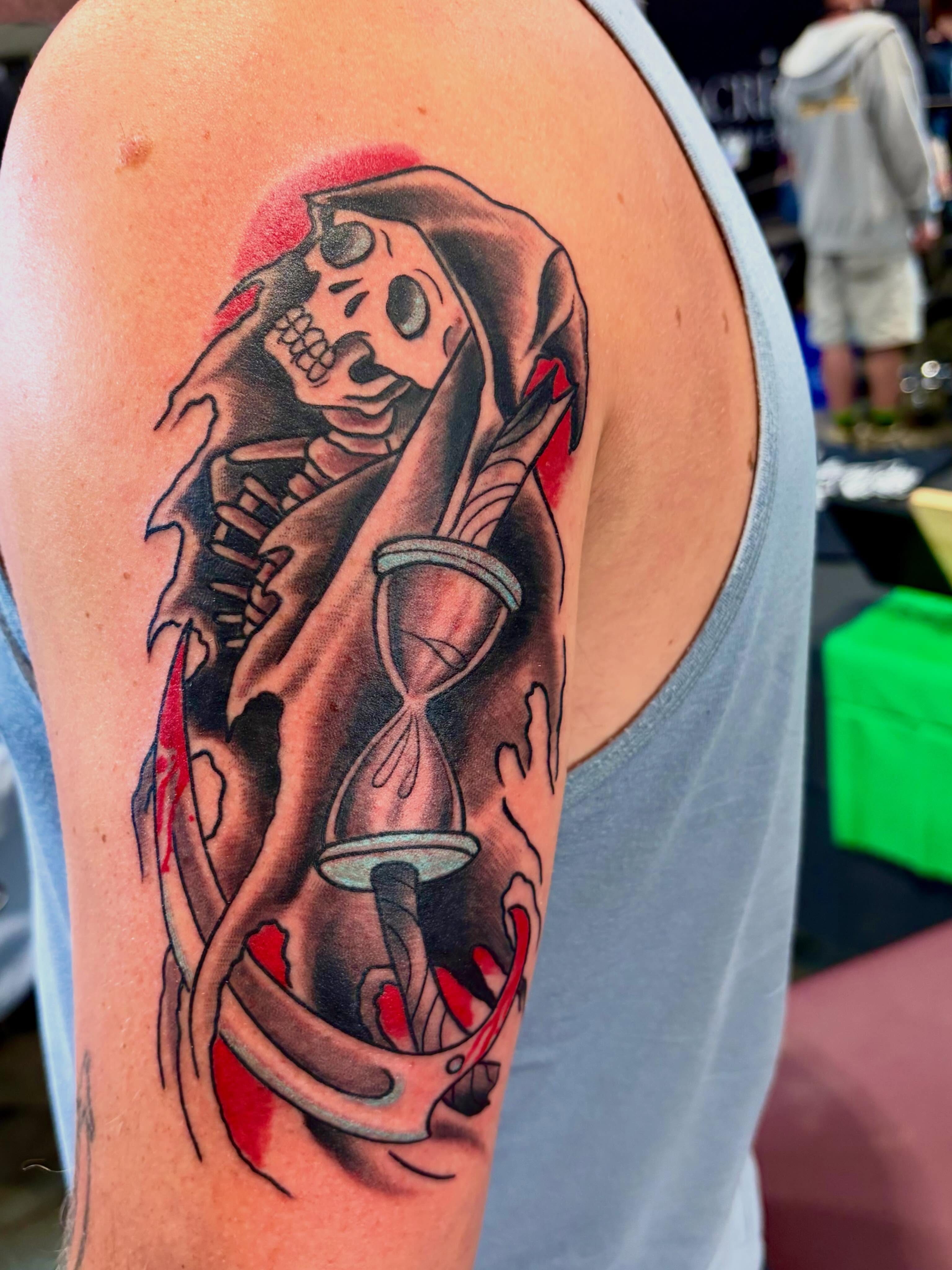 Hourglass and hooded figure American traditional tattoo on the upper arm by @rayscott_tattoo