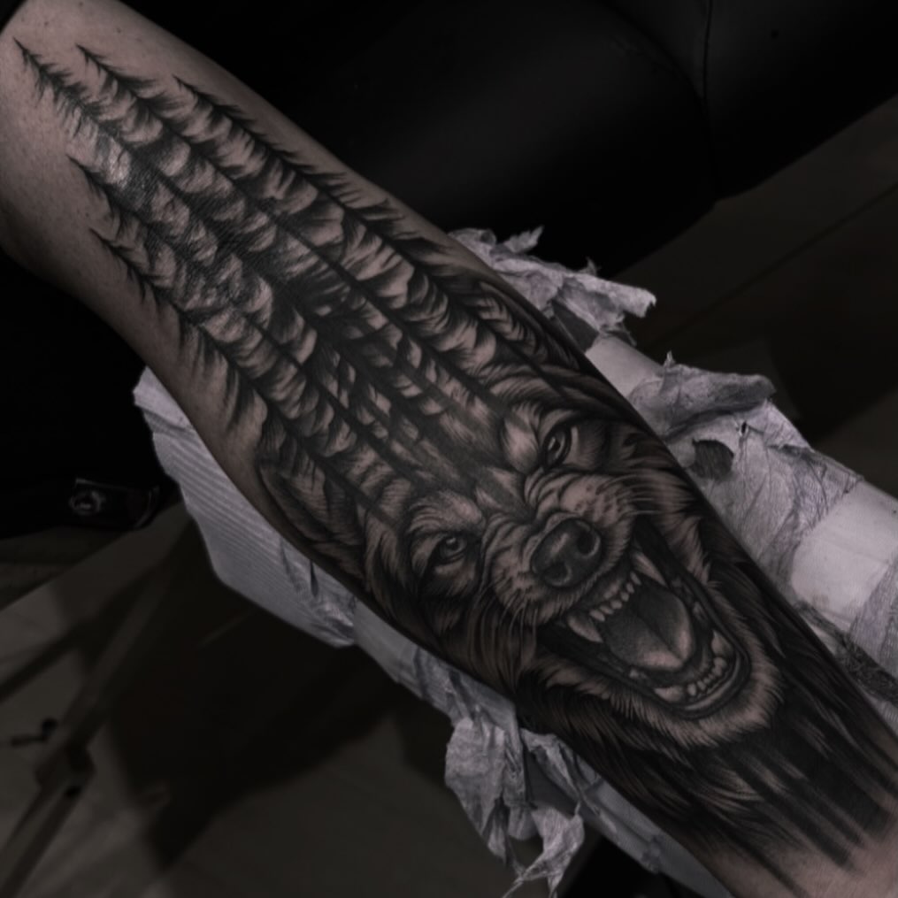 Wolf and forest realism tattoo on the forearm by Anna Nicole Thomas