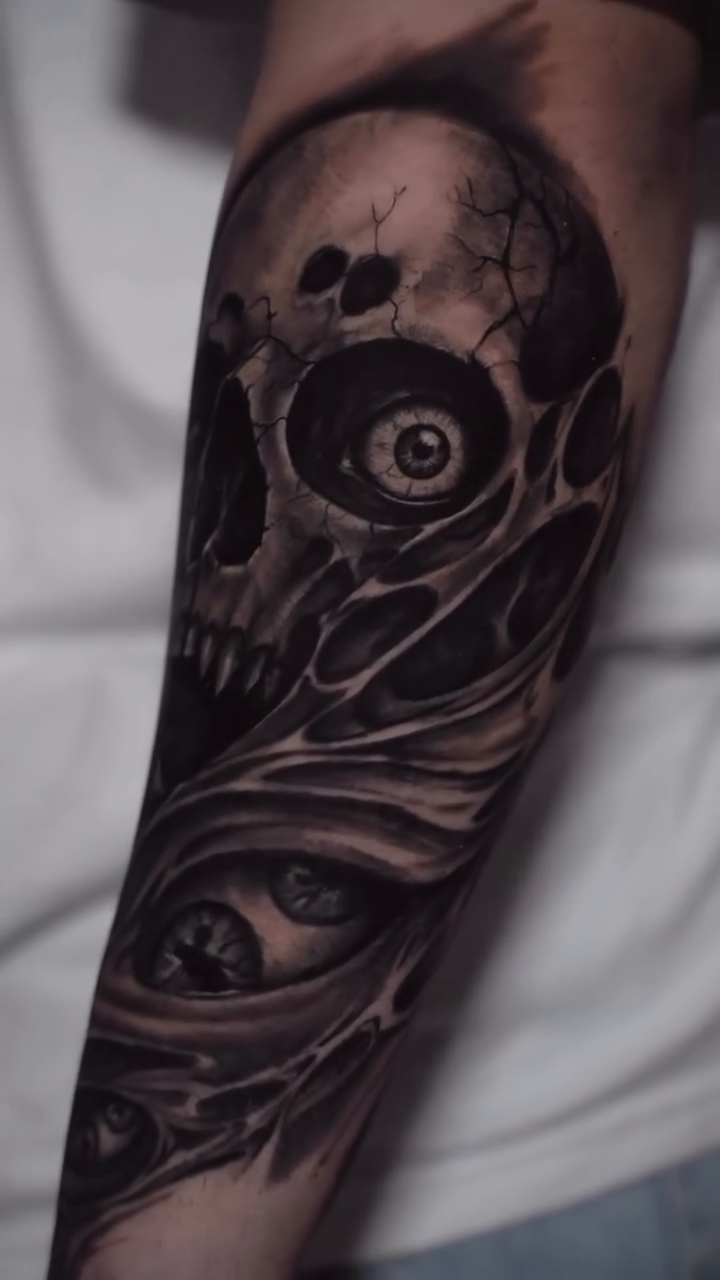 Demonic skull and face collage dark art tattoo on the forearm by Juan Russo