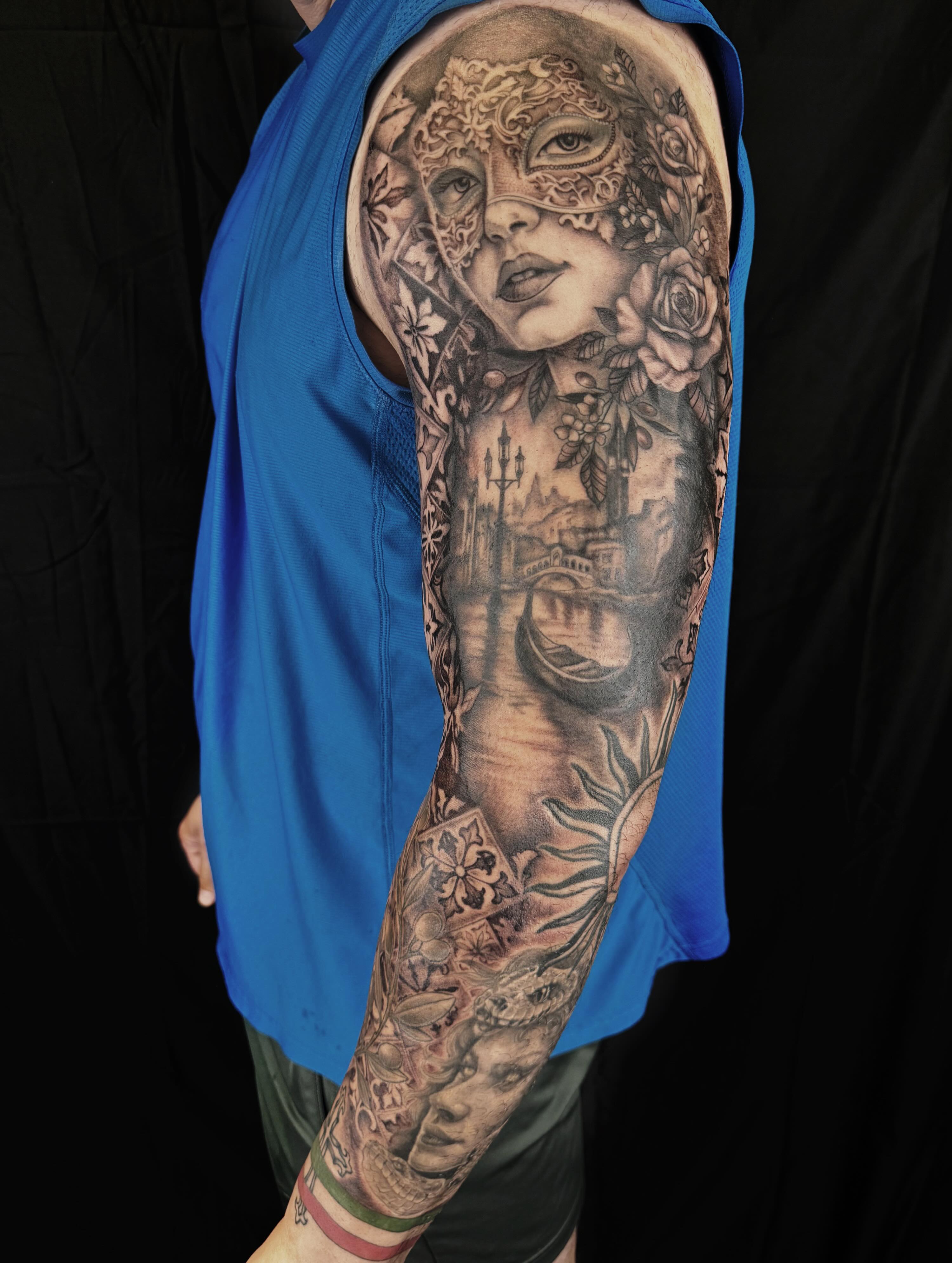 Mask and cityscape realism tattoo on the forearm by Brookelyn