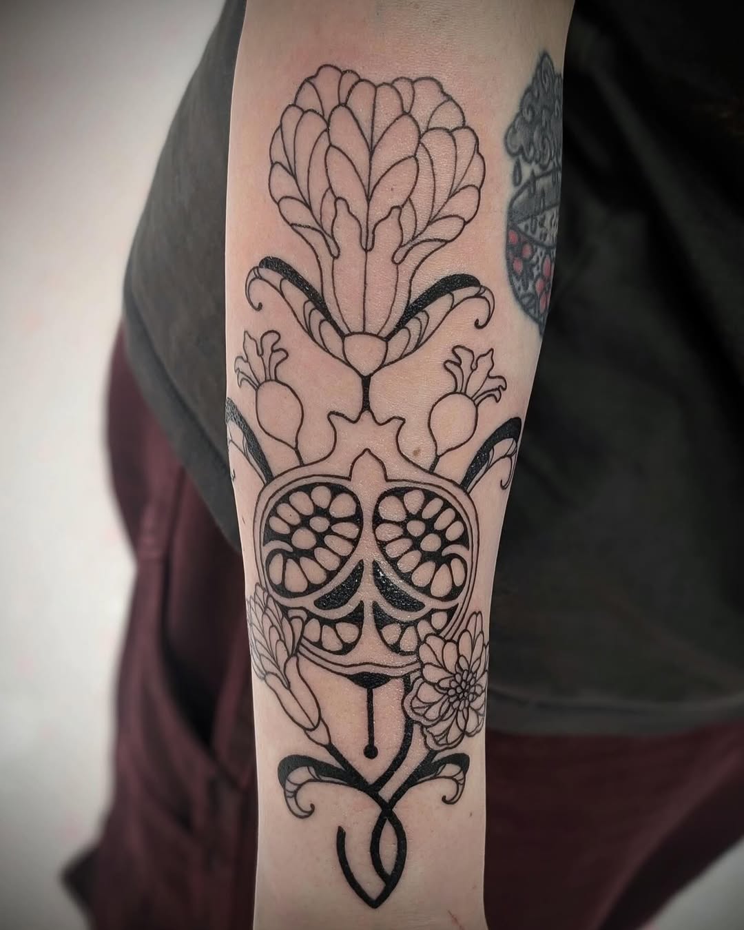 Pomegranate and flowers ornamental tattoo on the forearm by Rhiannon
