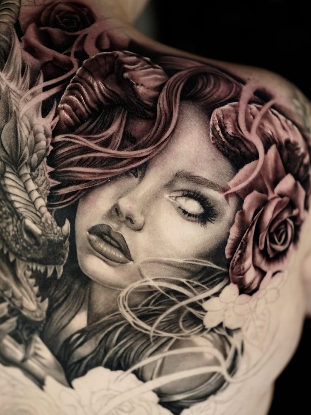 Woman with dragon and roses realism tattoo on the shoulder by April Lynn