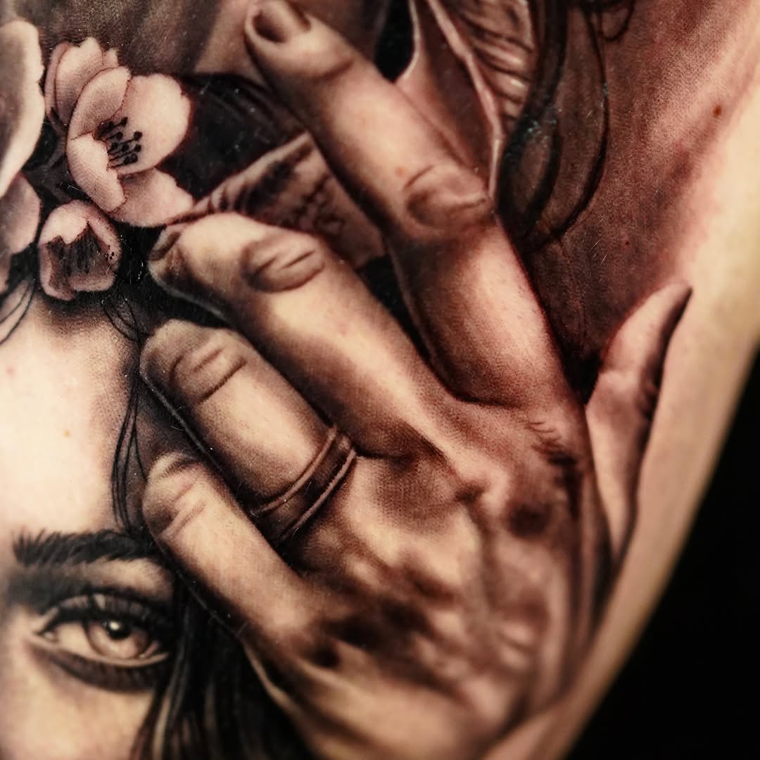 Woman's face and hand realism tattoo on the shoulder by April Lynn