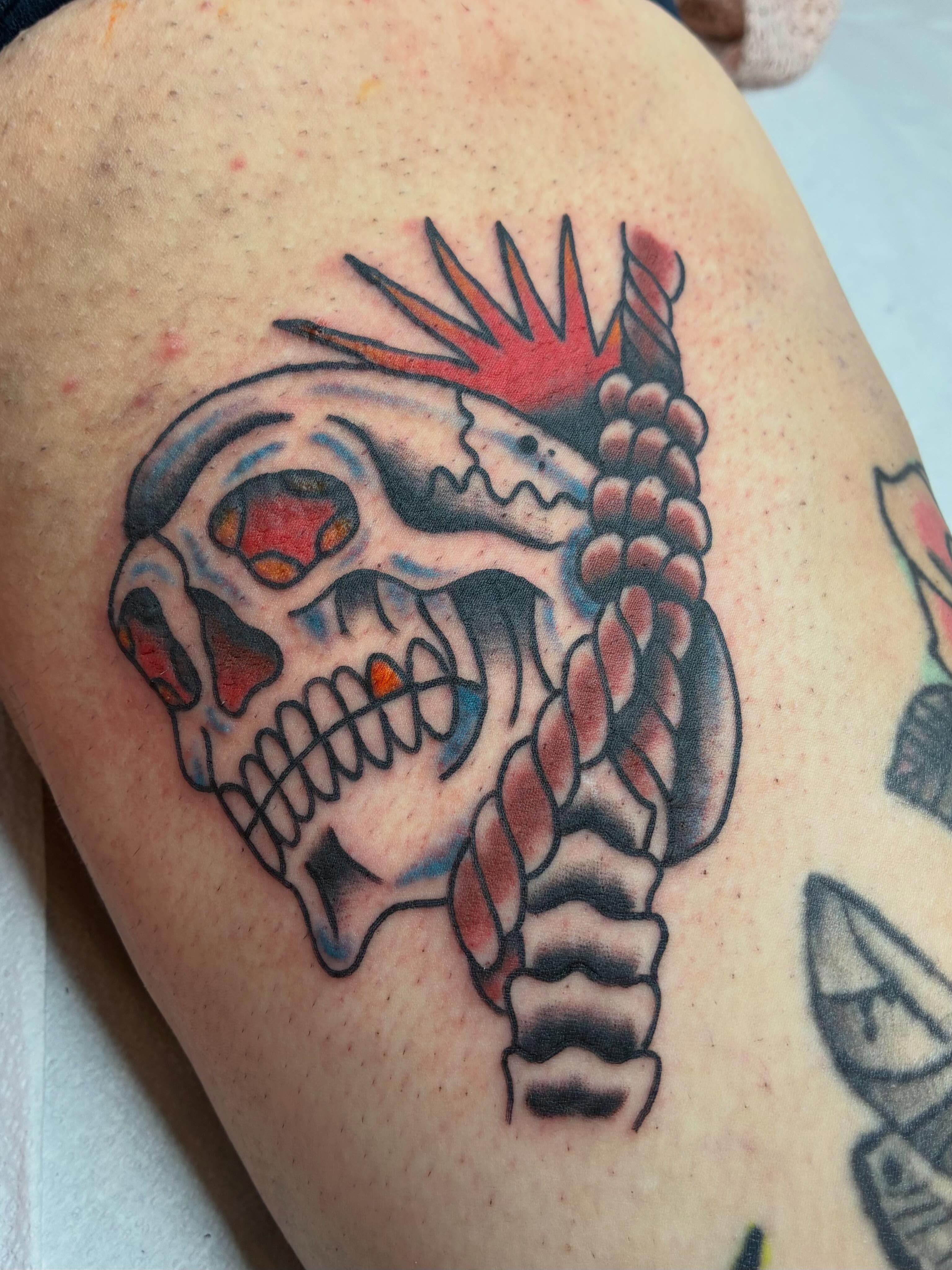 Skull with mohawk American traditional tattoo on the thigh by @spicy.curry.tattoos