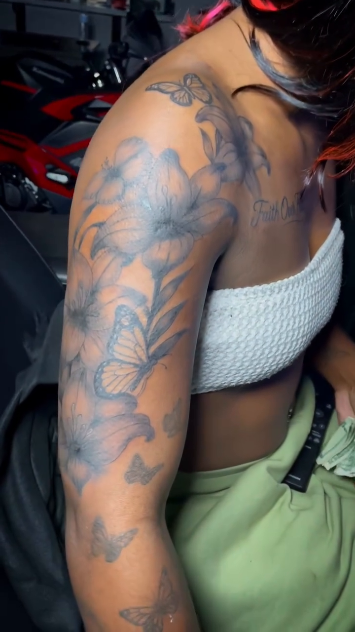 Floral sleeve with butterflies and script fine line tattoo on the upper arm by The Reelist Ink