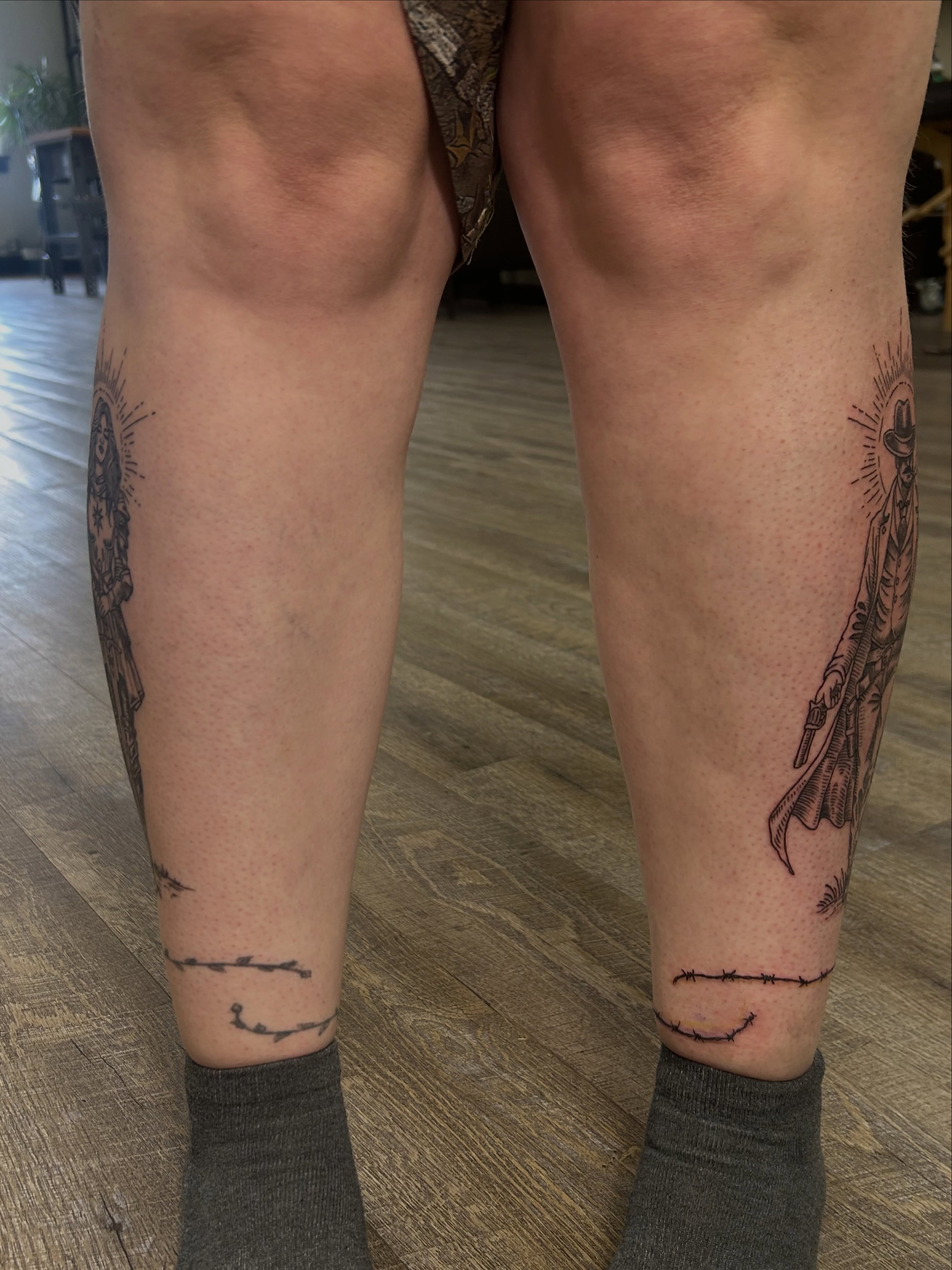 Cowboy and sun black and grey tattoo on the calf by Kaylee