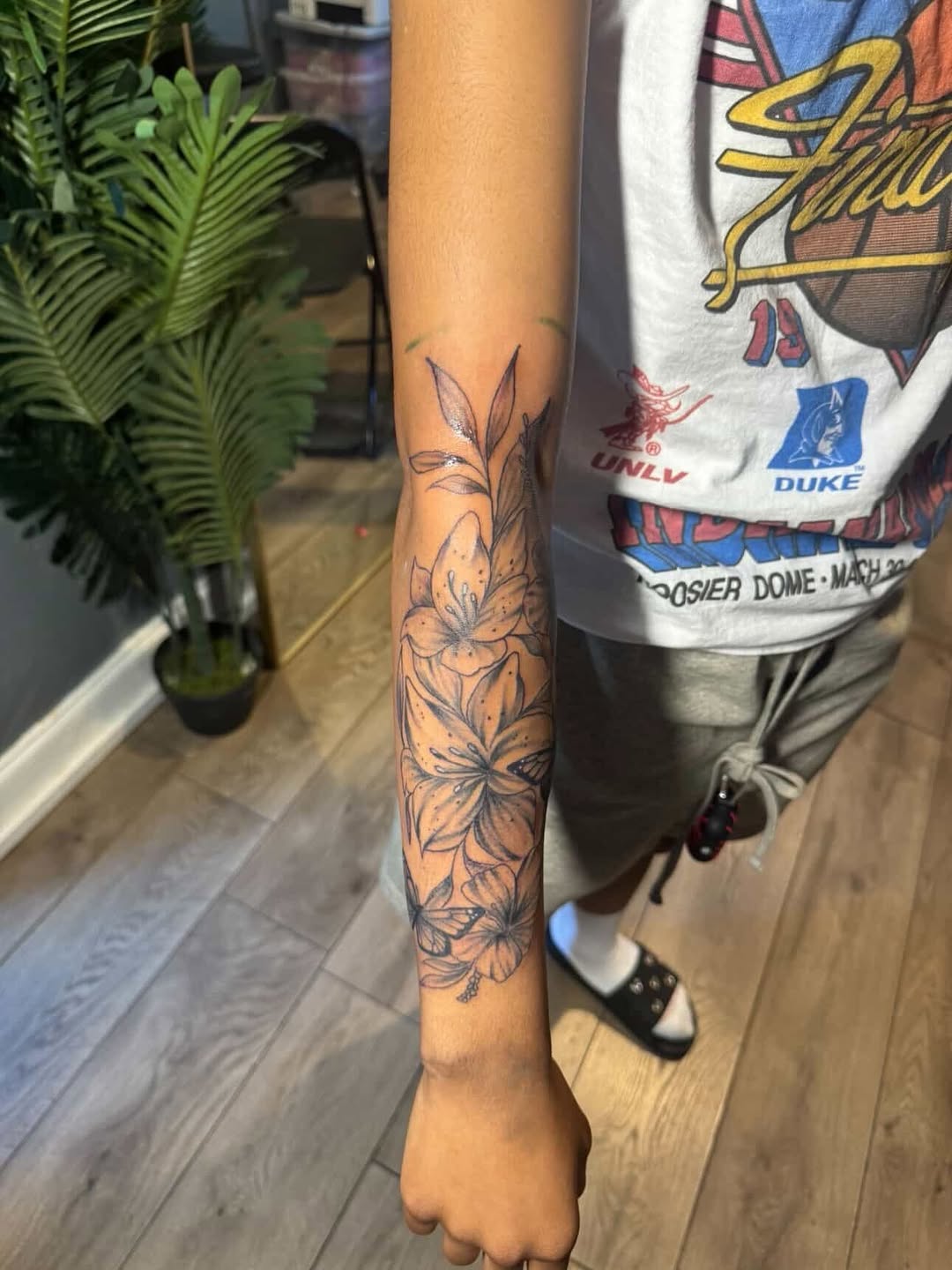 Lilies and butterflies fine line tattoo on the forearm by SpicyMvstardInkk