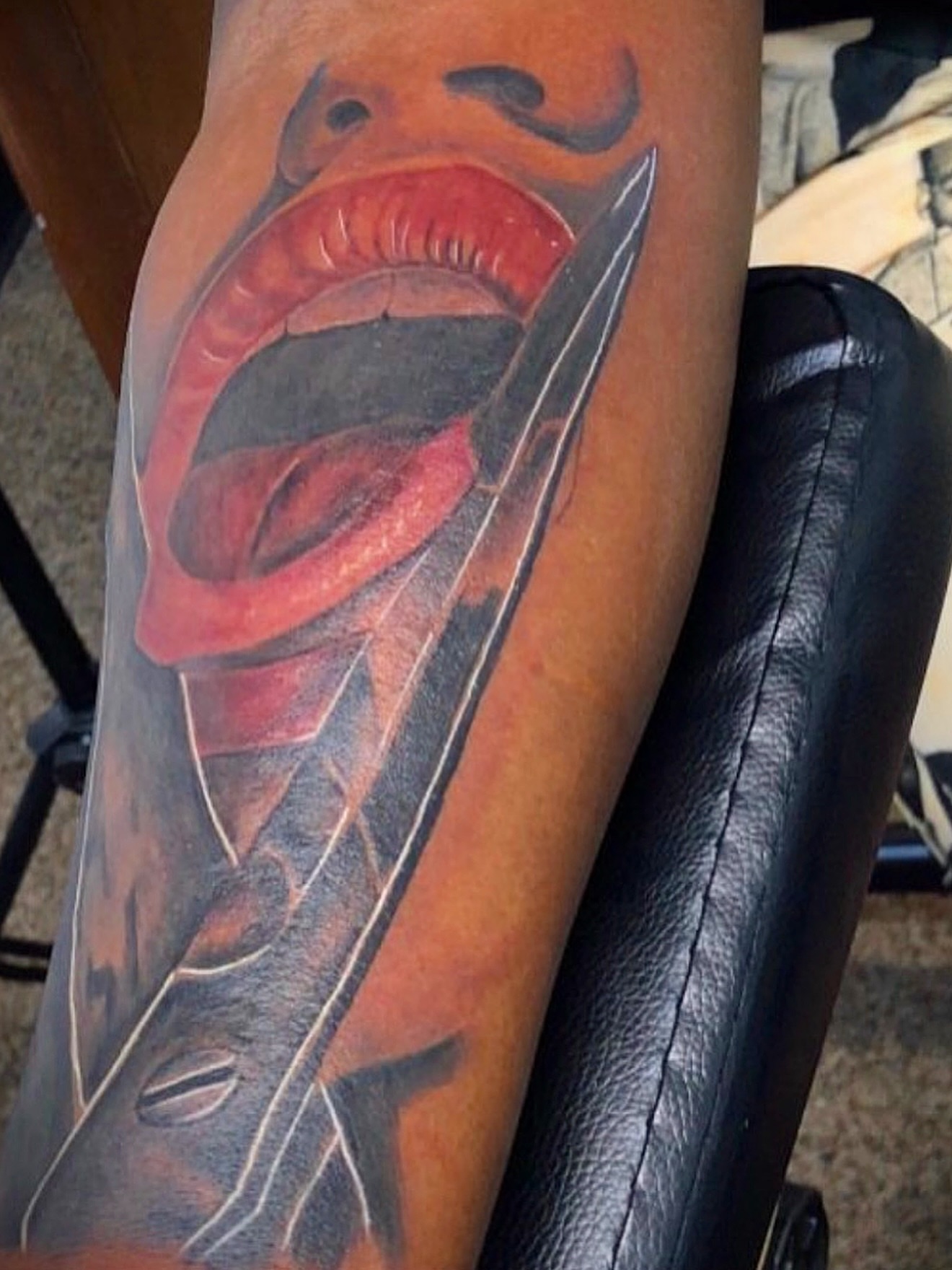 Open mouth with feather realism tattoo on the forearm by Deonte Dwayne Durham