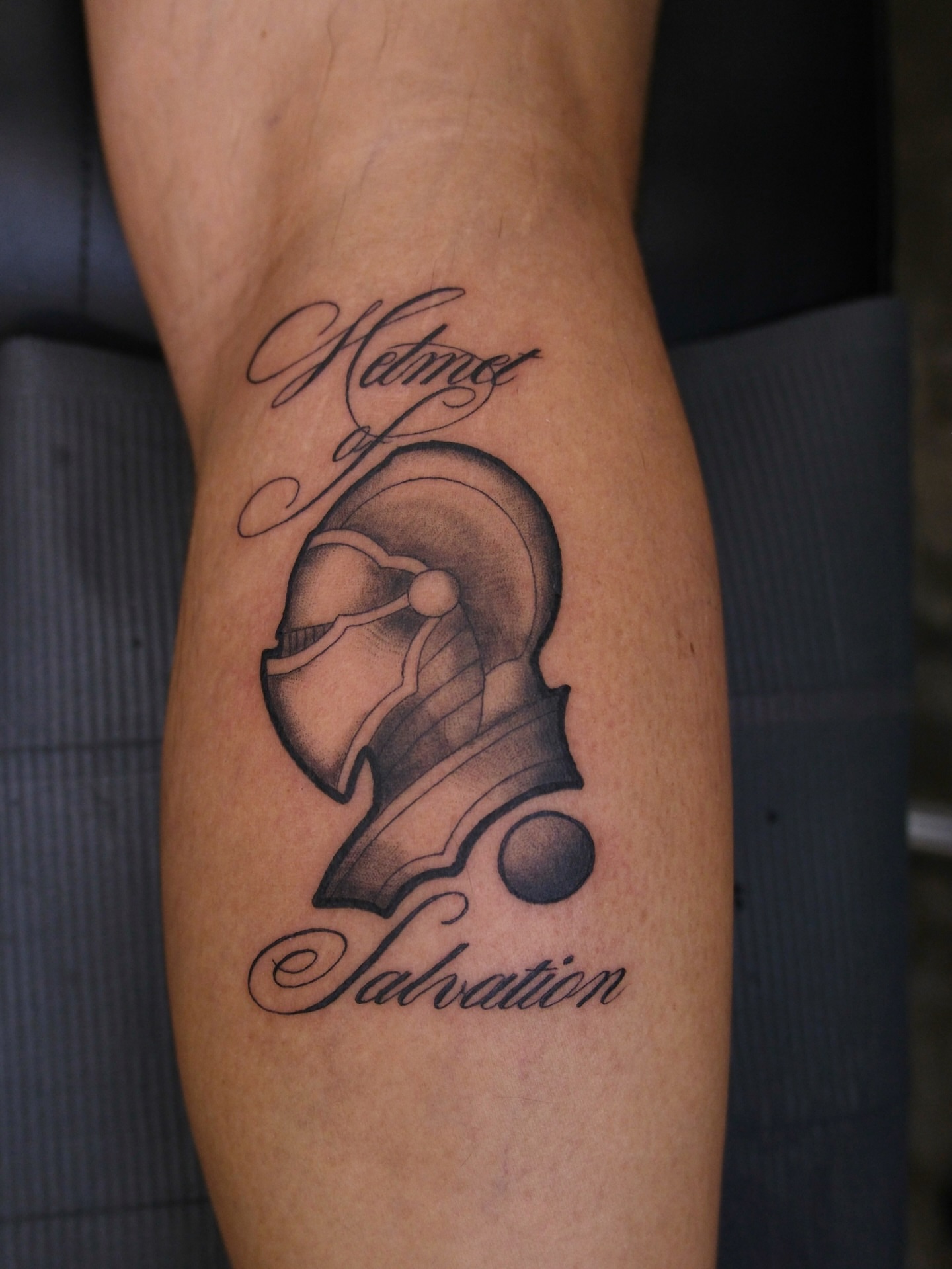 Helmet black and grey tattoo on the forearm by Kiana Hope