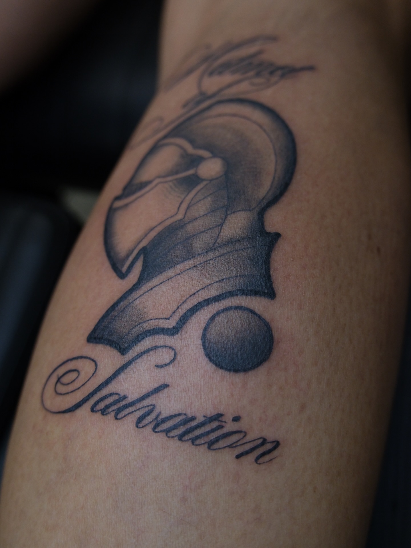 Helmet and sphere black and grey tattoo on the forearm by Kiana Hope