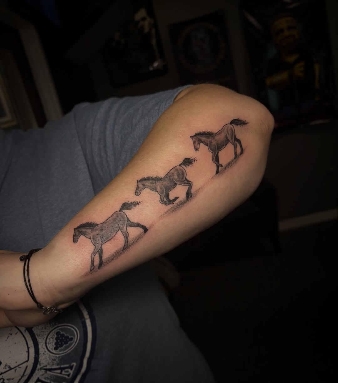 Horses black and grey tattoo on the forearm by Anastasia Carrasco