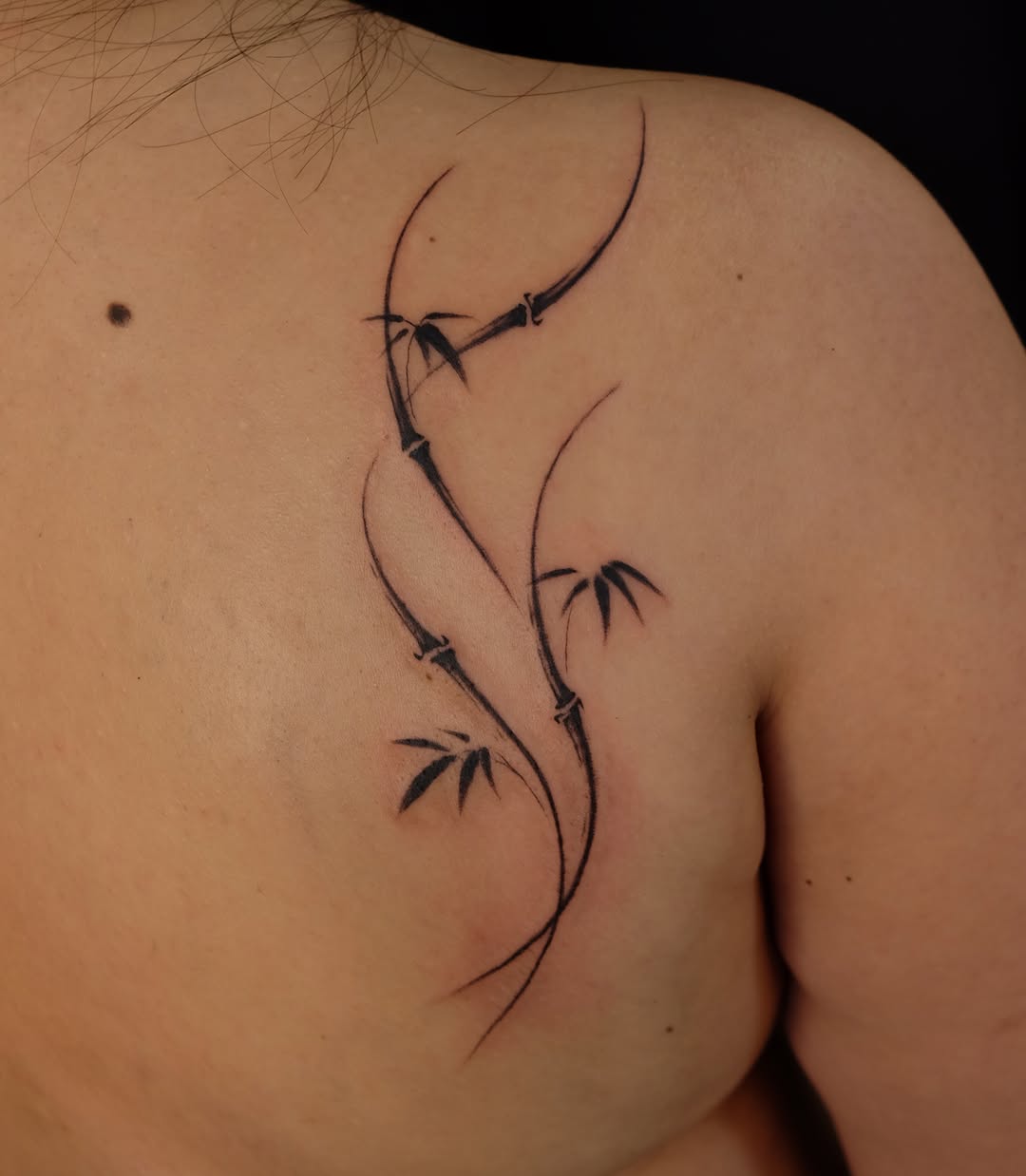 Bamboo branch blackwork tattoo on the shoulder by lela