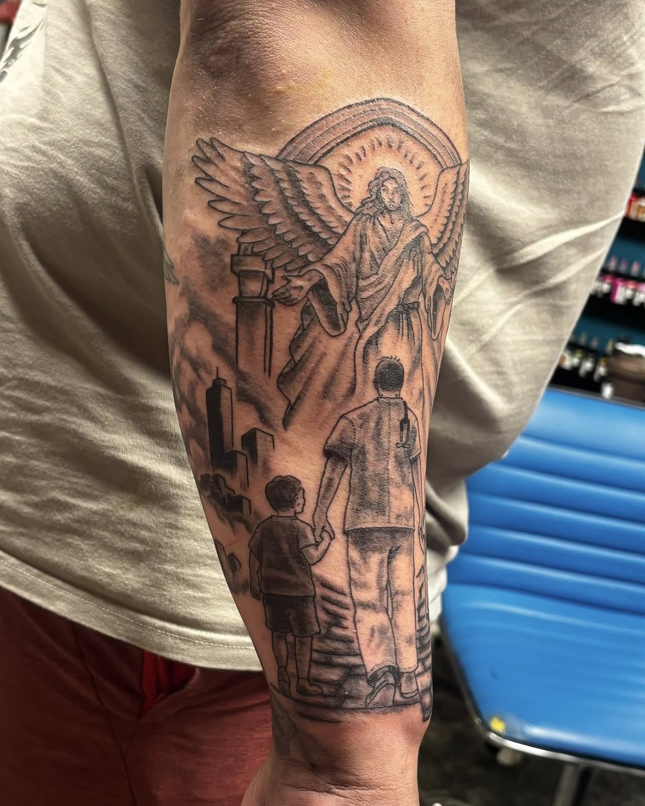 Angel with cityscape realism tattoo on the forearm by Jeff Zuptich