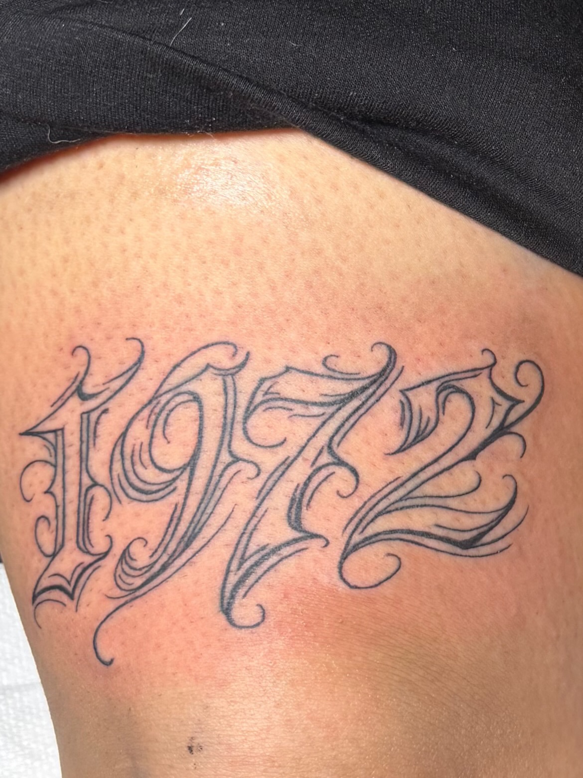 1972 lettering script tattoo on the thigh by Star Tattoos ⚜️