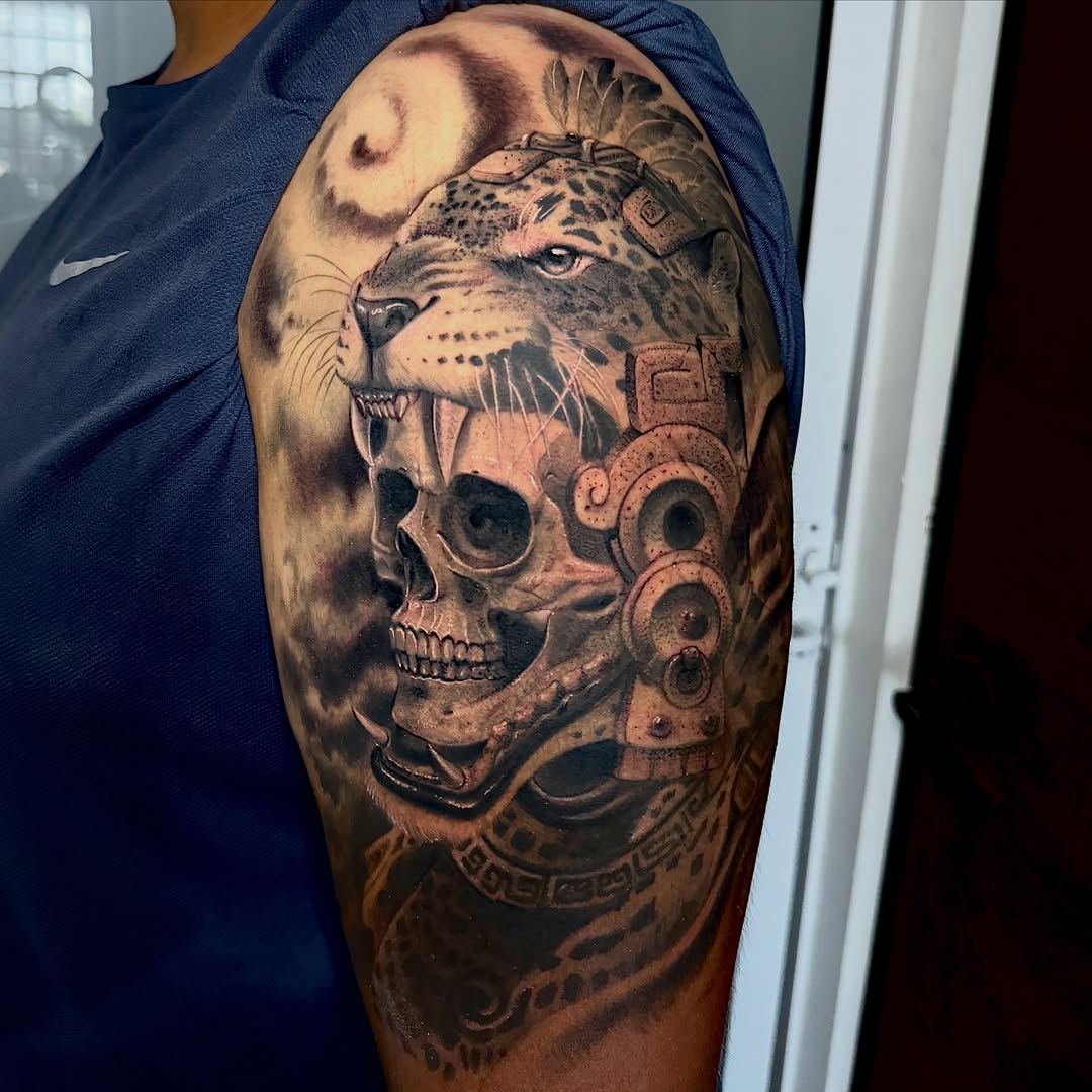 Jaguar skull headdress realism tattoo on the upper arm by Meza Cruz