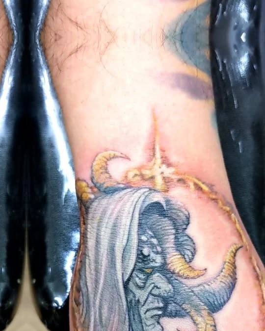 Horned creature with hood dark art tattoo on the forearm by Katelyn Bartoletti